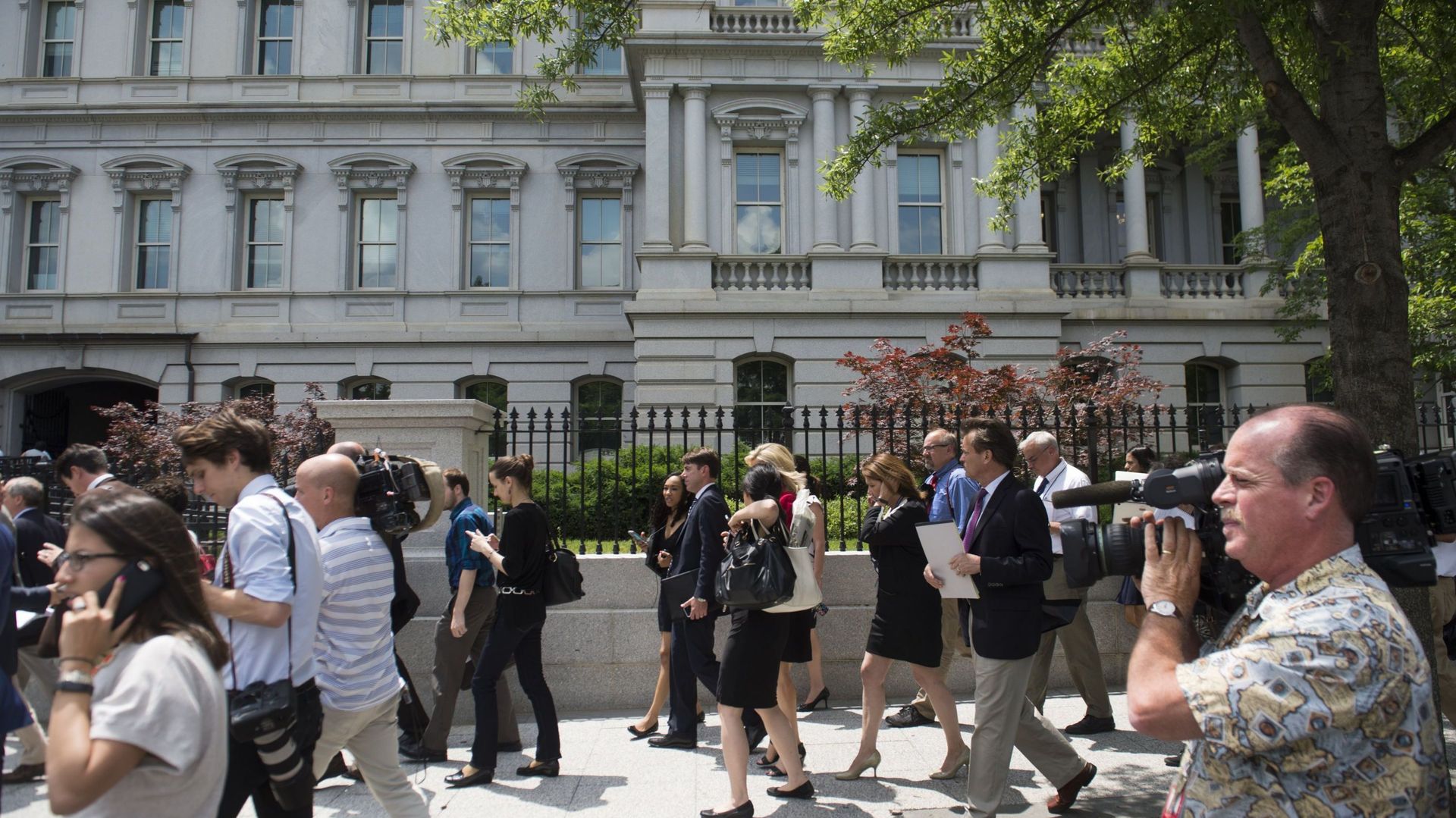 Des membres de la presse passent devant le bâtiment du bureau exécutif Eisenhower après l'évacuation de la salle de presse de la Maison Blanche.