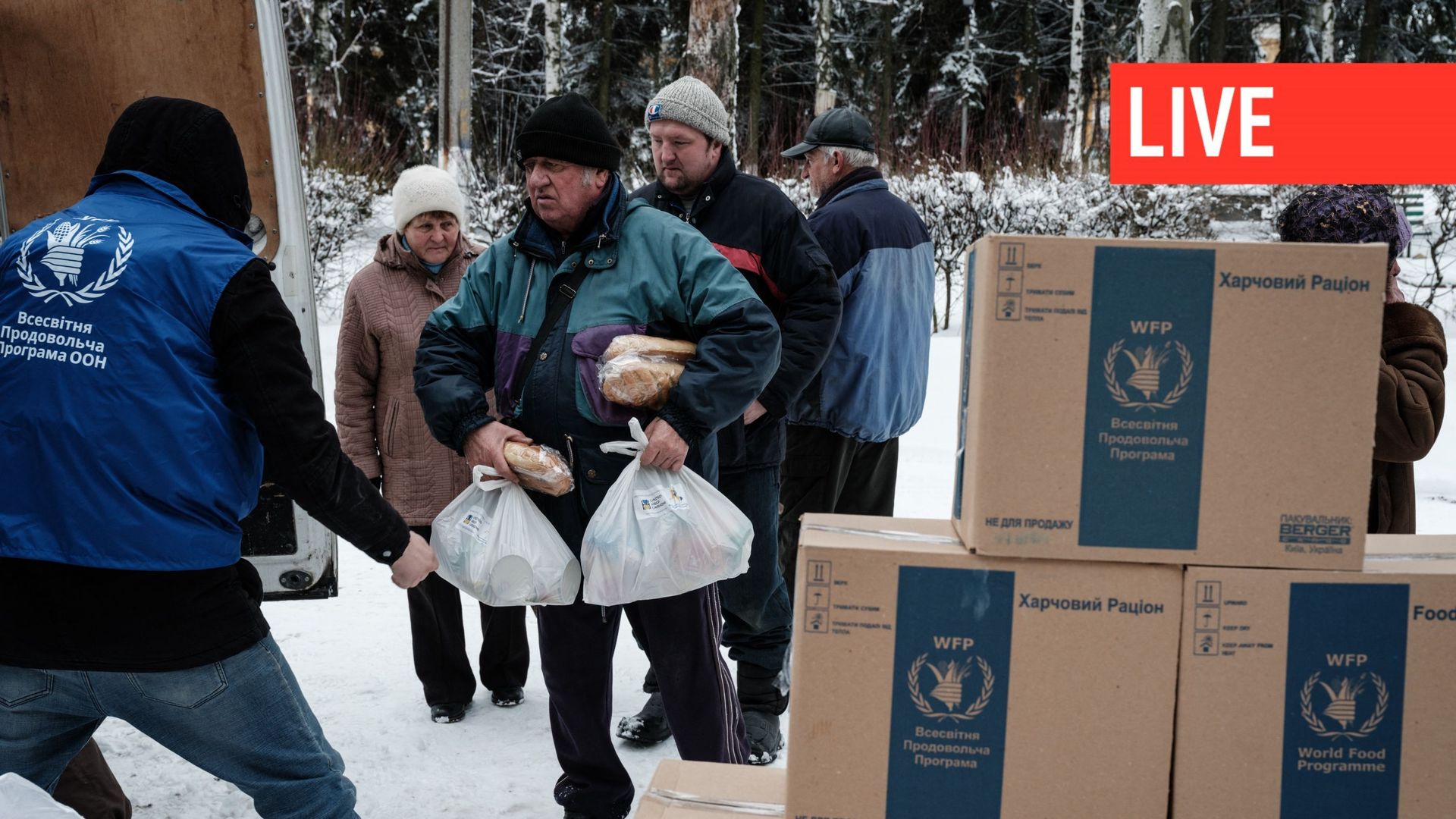 Des habitants reçoivent des boîtes de rations alimentaires fournies par le Programme alimentaire mondial (PAM) des Nations unies et distribuées par des bénévoles locaux à Chasiv Yar, le 14 février 2023.