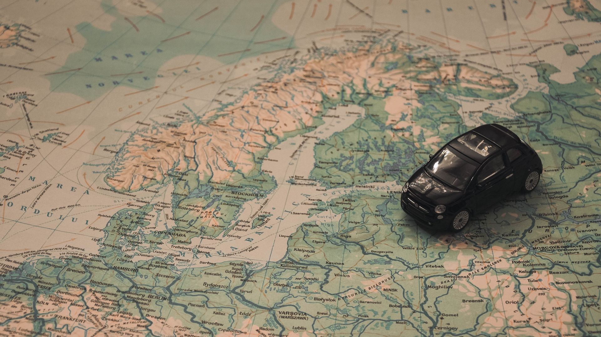 Une figurine de voiture posée sur une carte de l’Europe