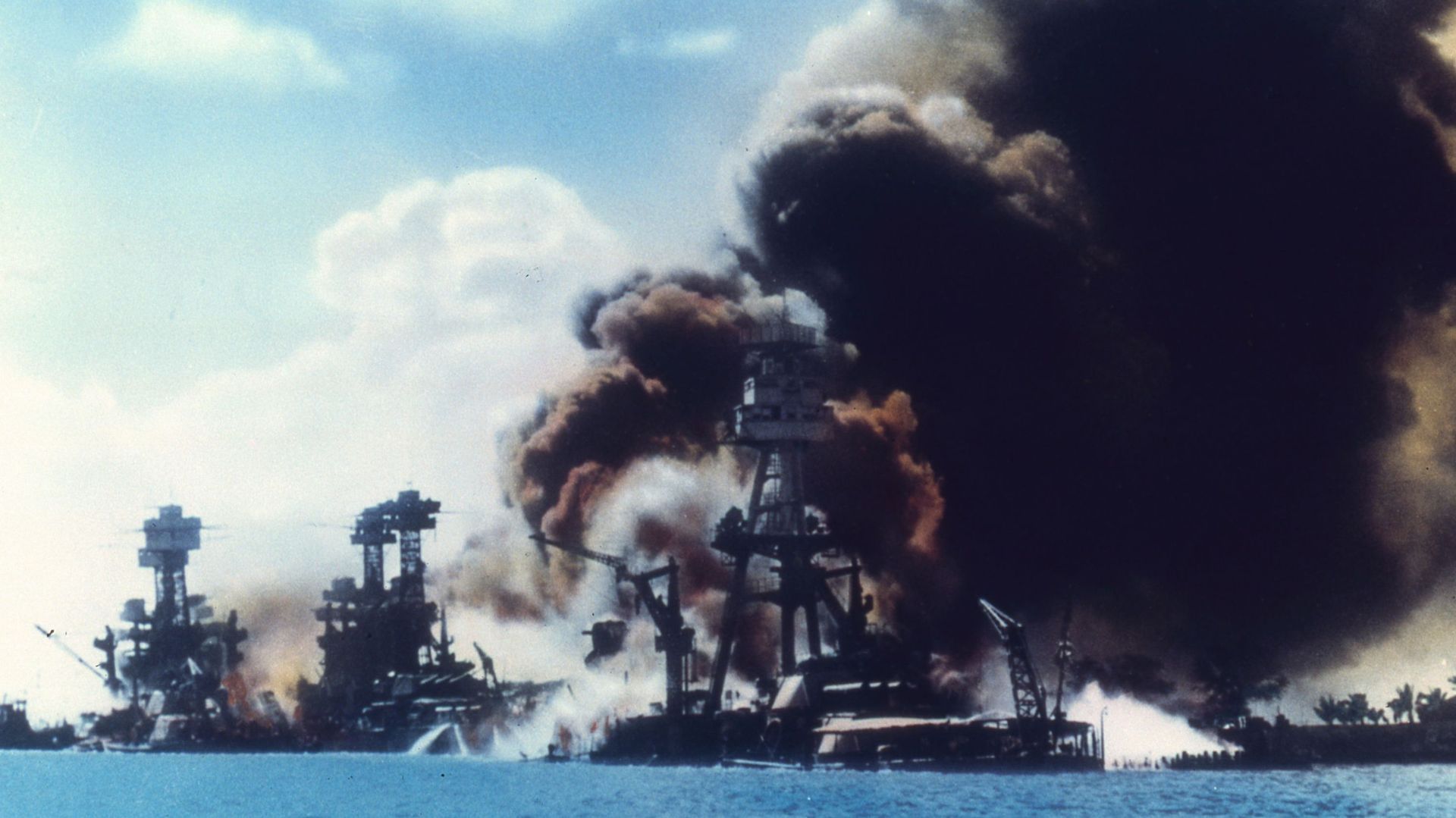Vue de la rangée de cuirassés alors que des explosions endommagent trois cuirassés américains pendant l'attaque japonaise sur Pearl Harbor, à Honolulu, Oahu, Hawaii, le 7 décembre 1941.