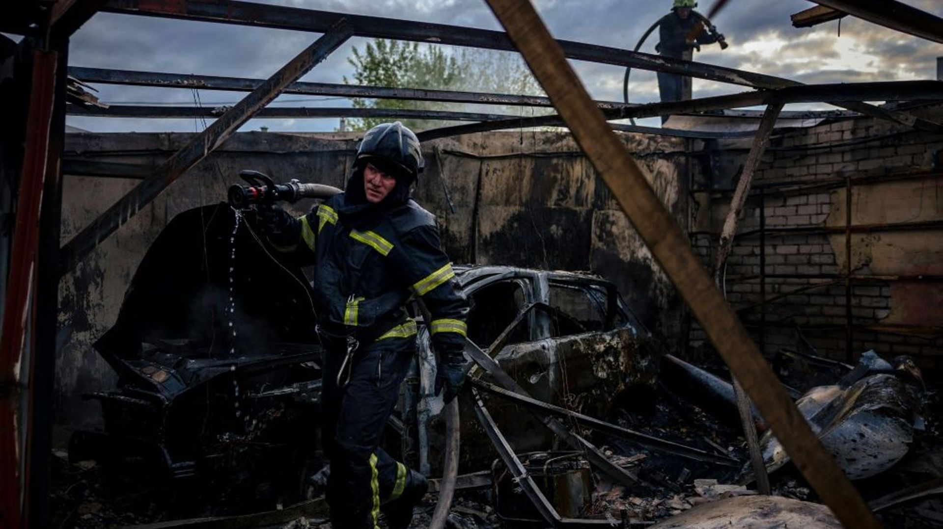 Des pompiers combattent un incendie après un bombardement, à Kharkiv dans l’Est de l’Ukraine le 27 avril 2022.