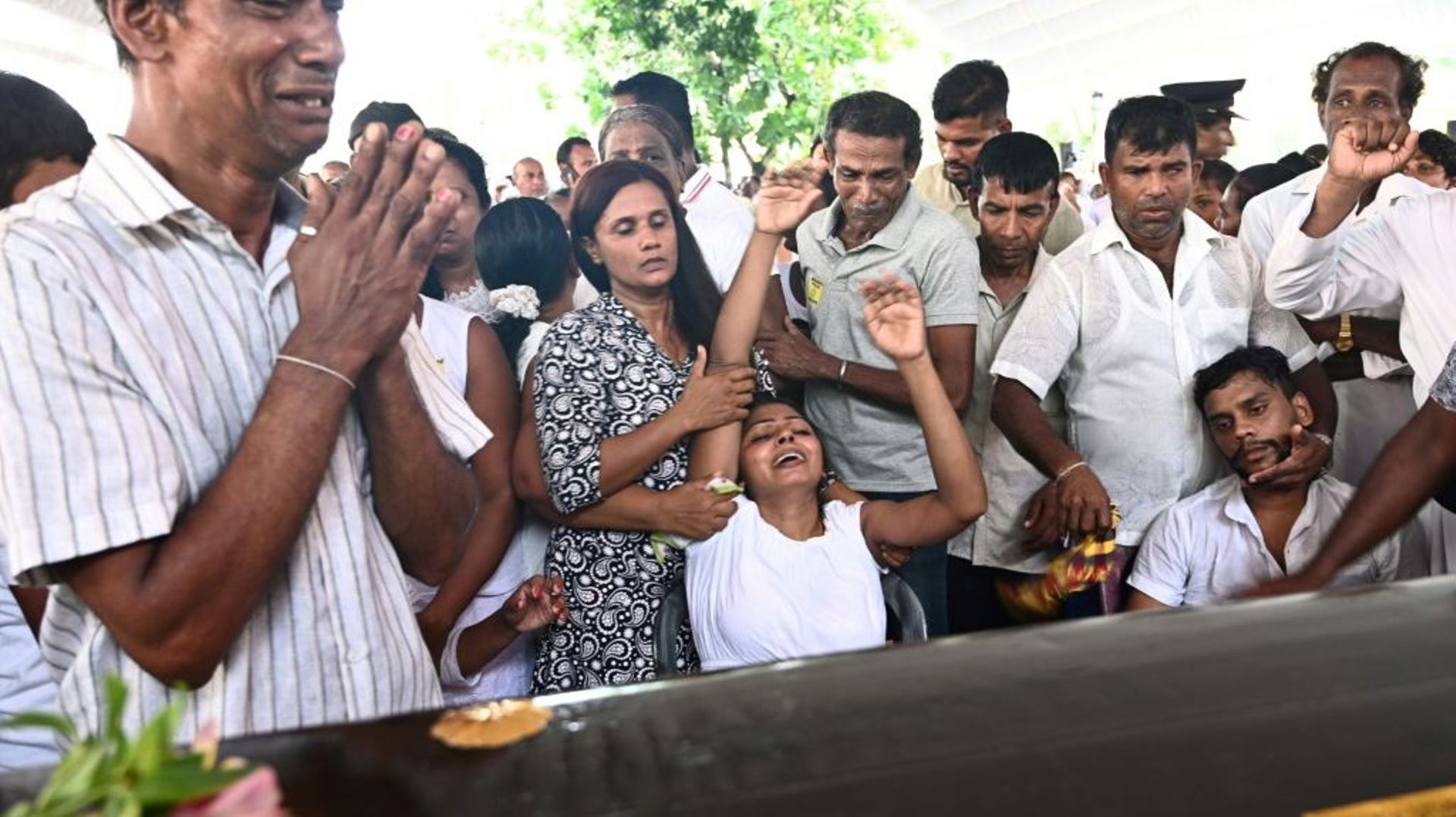 Des proches pleurent devant le cercueil d'une victime des attentats lors de funérailles à l'église Saint-Sébastien de Negombo au Sri Lanka, le 23 avril 2019