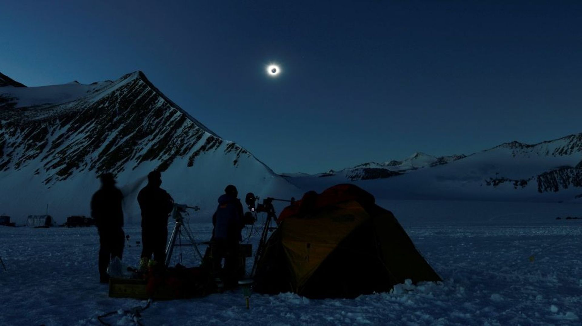 Photo prise par Imagen Chile montrant des scientifiques et touristes qui observent l'éclipse solaire, le 4 décembre 2021, en Antarctique