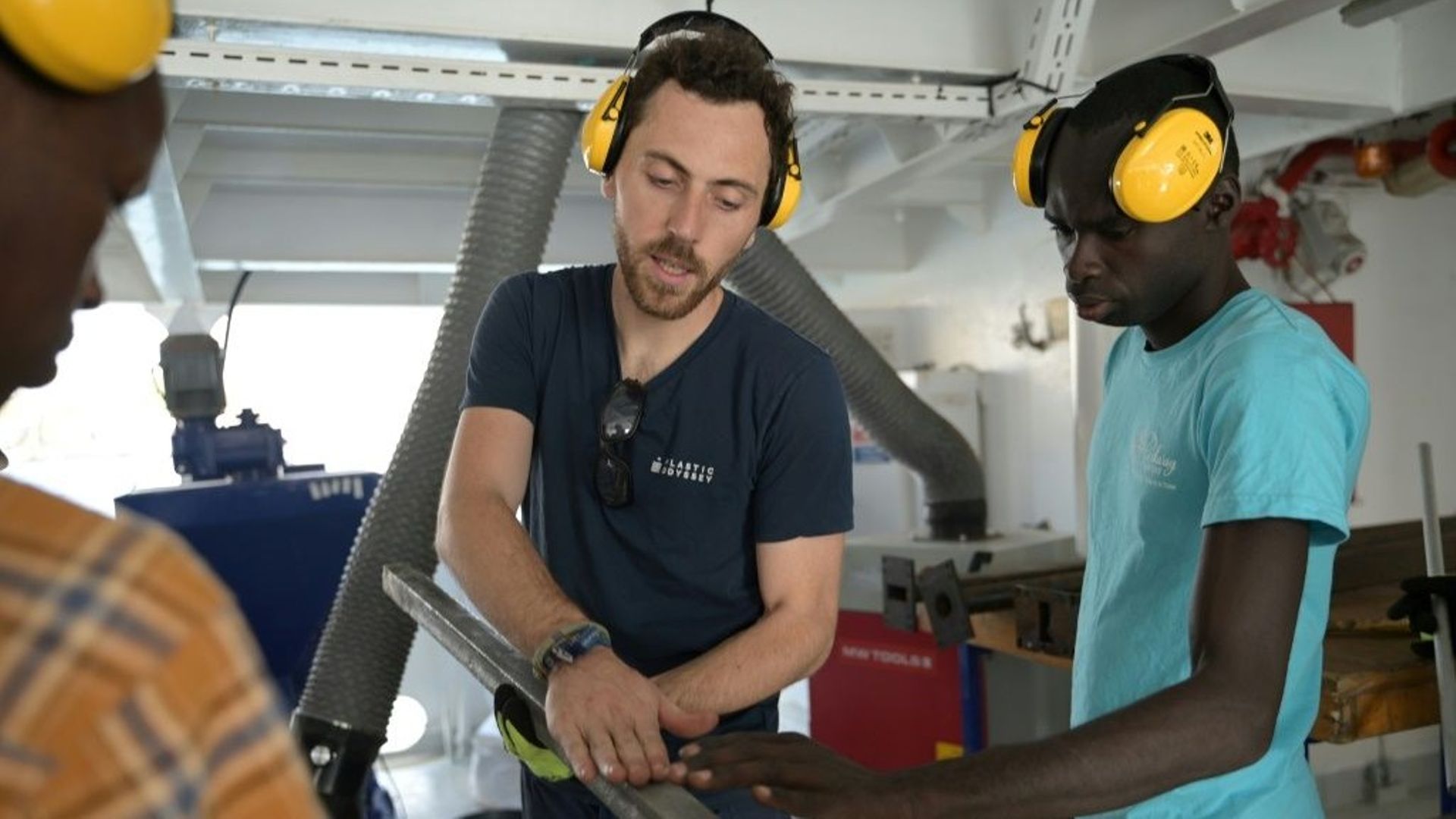 Un casque jaune vissé sur les oreilles, Baptiste Lomenech, explique à une dizaine de jeunes entrepreneurs du Sénégal le fonctionnement de l'extrudeuse, une machine qui sert au recyclage du plastique.