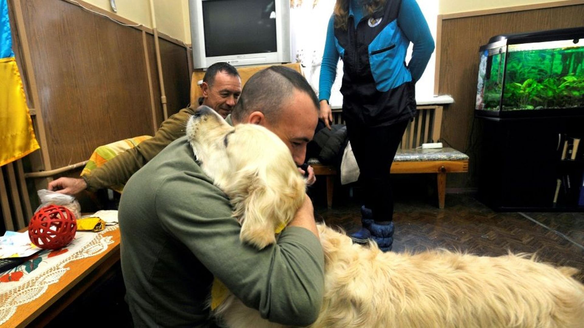 Un soldat souffrant de syndrome de stress post-traumatique embrasse un chien dans l'enceinte de l'hôpital à Kiev le 13 février 2020 dans le cadre d'un programme pour gérer les cas de SSPT 
