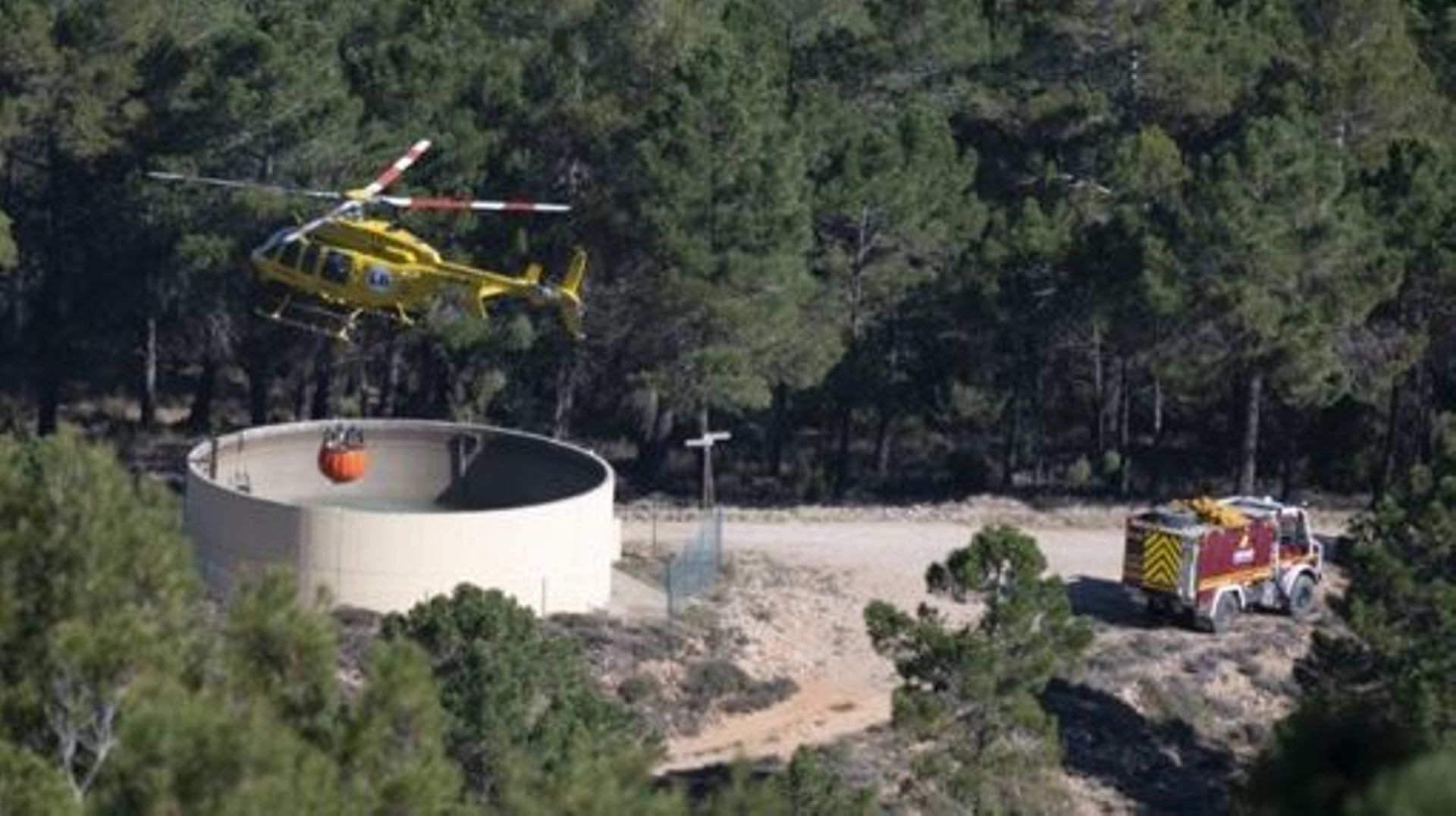 A helicopter loads water near the village of Los Peiros, on March 25, 2023, to fight a wildfire that began on March 23, 2023 near Villanueva de Viver, some 90 kilometres (55 miles) north of Valencia. Hundreds of firefighters today were battling Spain’s fi