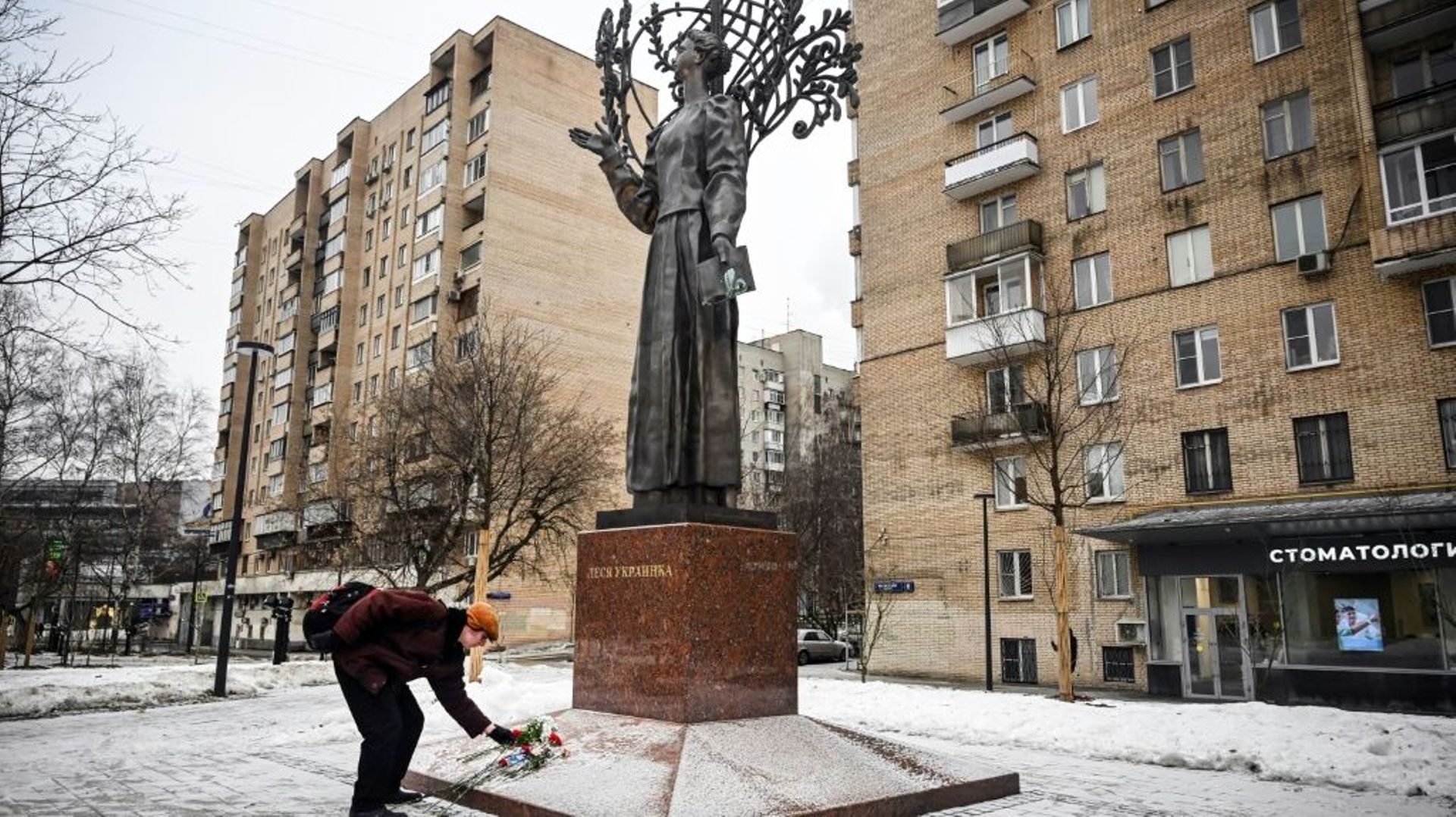 Un homme dépose des fleurs à la mémoire des personnes tuées lors d’une récente frappe contre un immeuble résidentiel de la ville ukrainienne de Dnipro, au monument de la poétesse ukrainienne Lesya Ukrainka à Moscou le 23 janvier 2023.