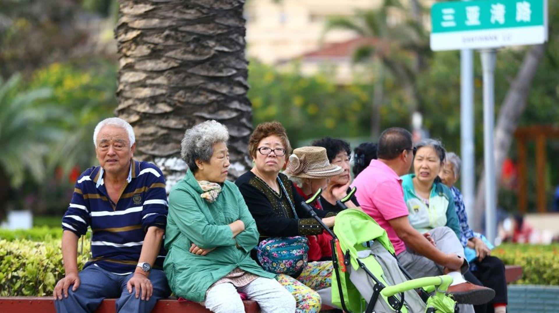 Des Chinois retraités se reposent assis sur un banc le long de la plage de Sanya, le 15 février 2017 sur l'île de Hainan