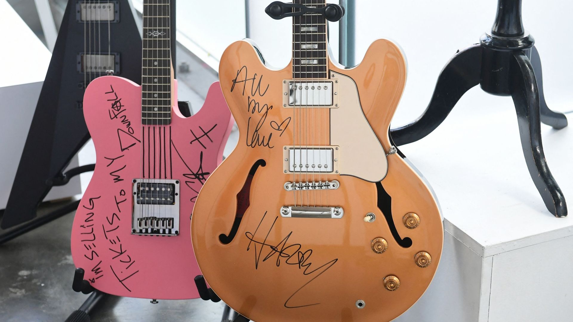 Des guitares signées par Machine Gun Kelly (à gauche) et Harry Styles (à droite) sont exposées chez Julien’s Auctions à Beverly Hills, en Californie, le 6 décembre 2021. Les enchères de Julien’s Auctions et Musicares Charity Relief Auction auront lieu le