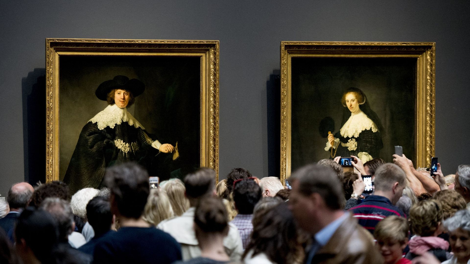 Des visiteurs se tiennent devant les deux tableaux 'Marten' et 'Oopjen' de Rembrandt (1606-1669) au Rijksmuseum d’Amsterdam, le 2 juillet 2016, lors de la première journée publique pour les tableaux, acquis conjointement par les Pays-Bas et la France, et 