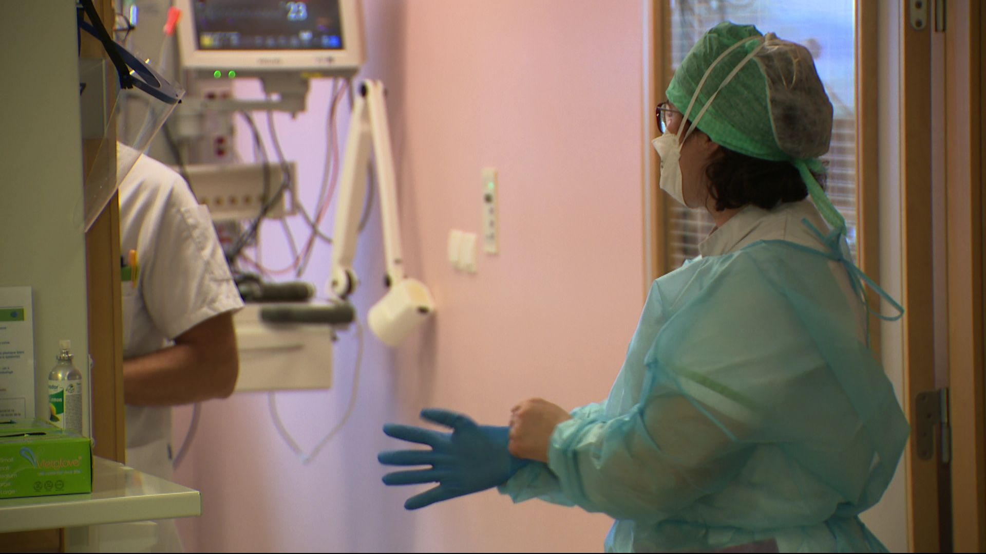 Infirmière soins intensifs se préparant à rentrer dans une chambre de patient covid au CHU-UCL Namur site de Dinant.