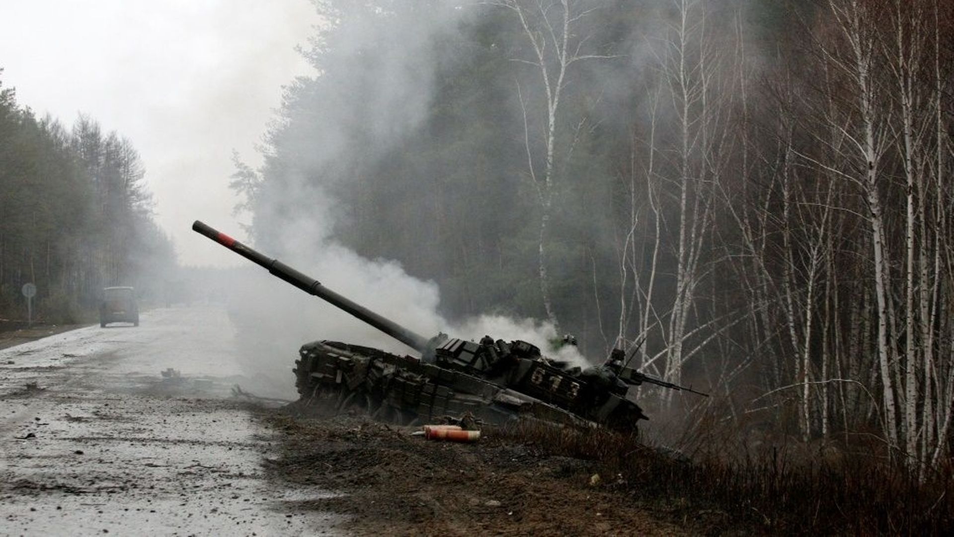 De la fumée s’échappe d’un char russe détruit par les forces ukrainiennes, au bord d’une route dans la région de Lougansk, le 26 février 2022