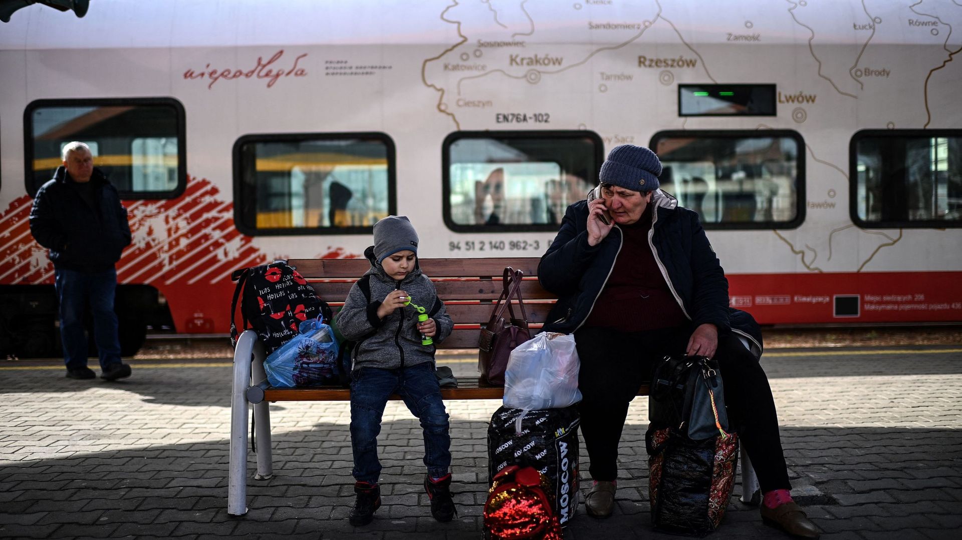 Des réfugiés ukrainiens sont assis sur un banc alors qu'ils attendent un train pour les emmener plus loin à l'intérieur de la Pologne sur un quai de la gare de Przemysl, dans l'est de la Pologne, le 7 avril 2022 (illustration)