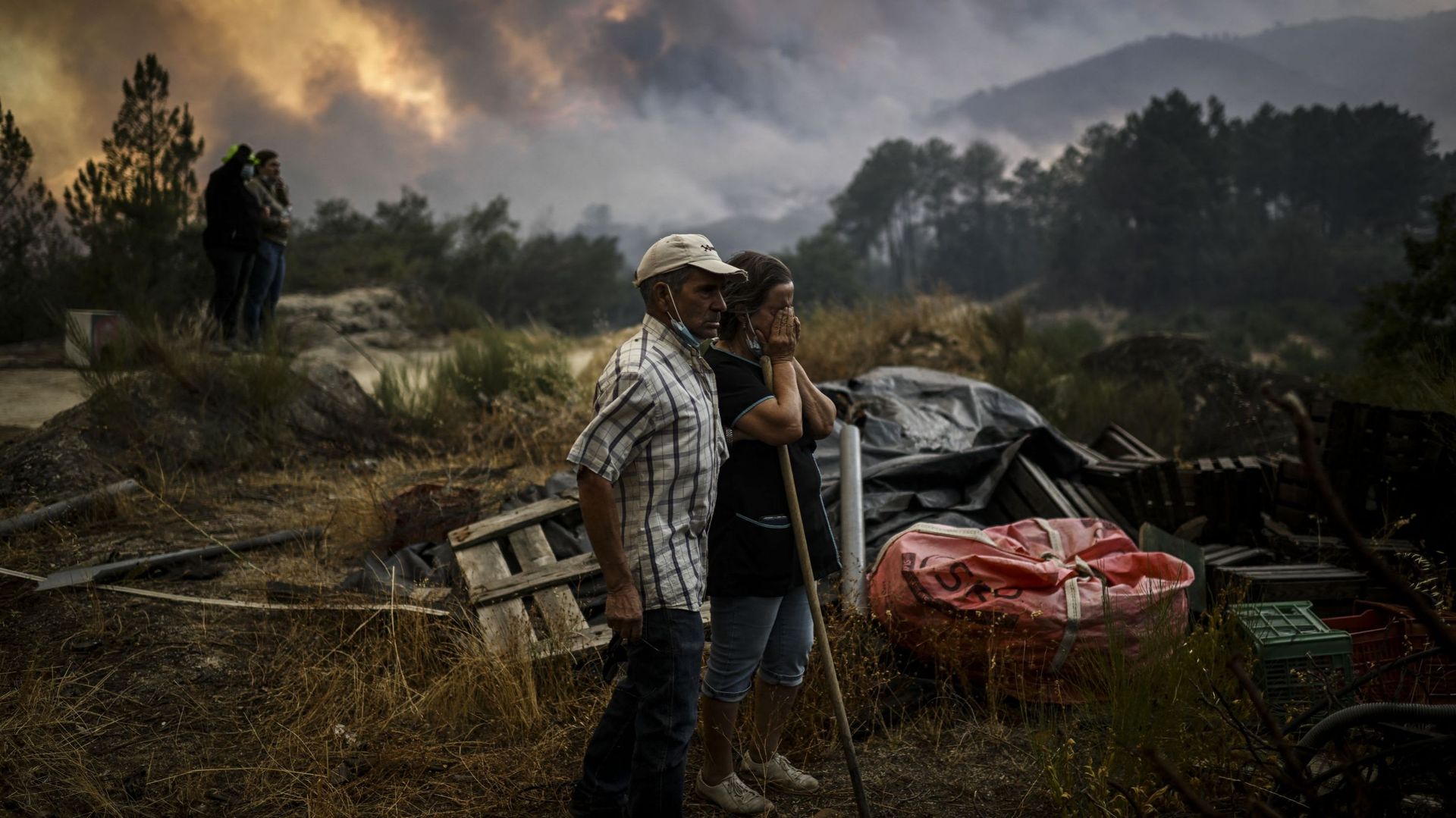 Des habitants regardent un feu de forêt progresser à Orjais, dans le conseil municipal de Covilha, dans le centre du Portugal, le 16 août 2022. 