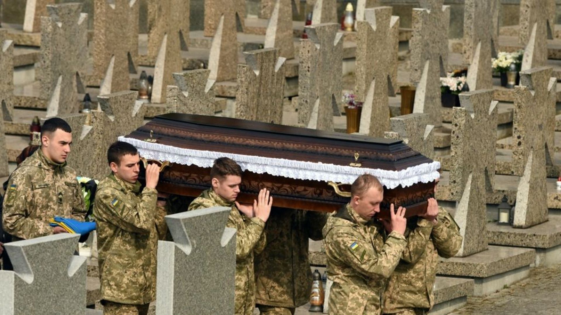 Des soldats ukrainiens portent le cercueil de l'un des leurs tué dans une attaque russe, le 29 mars 2022 au cimetière de Lviv