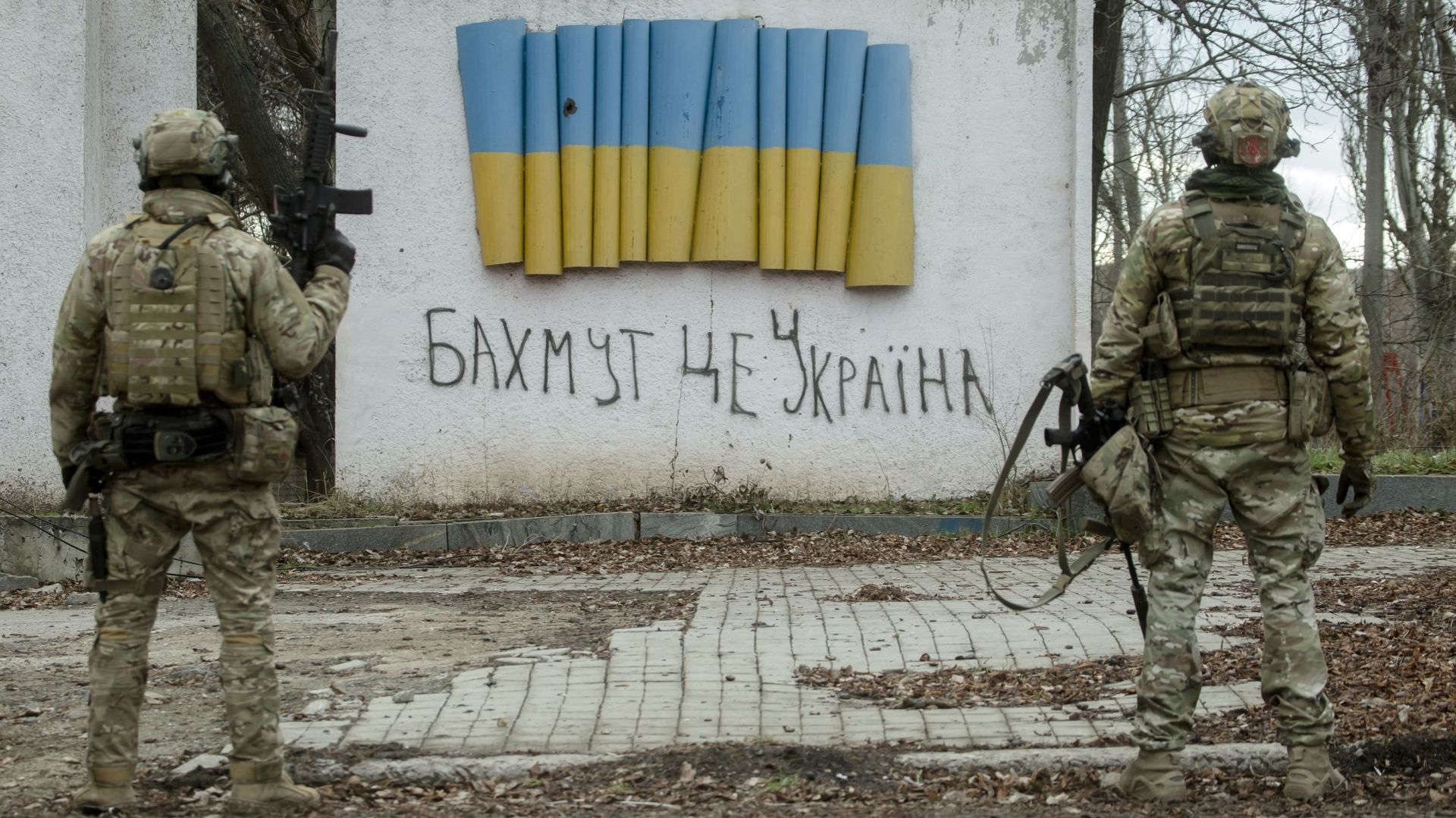 4 janvier 2023 à Bakhmut, Oblast de Donetsk. Des soldats ukrainiens se tiennent près d'une stèle avec un drapeau ukrainien et une inscription manuscrite disant: "Bakhmut est l'Ukraine".