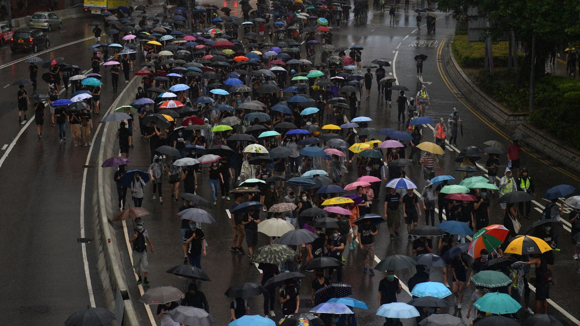 Des personnes prennent part à une marche de protestation sous la pluie dans le quartier d’Admiralty à Hong Kong, le 6 octobre 2019. Un juge de Hong Kong a rejeté le 6 octobre la contestation d’une loi d’urgence criminalisant les manifestants portant des m