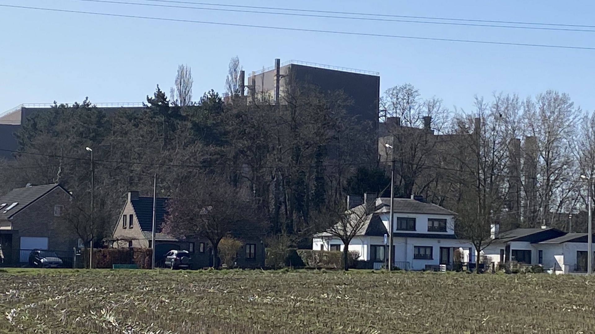 Derrière ces maisons de Hermalle-sous-Argenteau, un bâtiment de l’ancien site sidérurgique