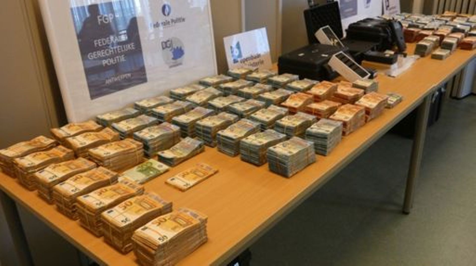Illustration : Saisie  d'argent liquide, des téléphones portables et d'autres biens confisqués et saisis dans les bureaux de la police judiciaire fédérale à Anvers, vendredi 12 août 2022.
