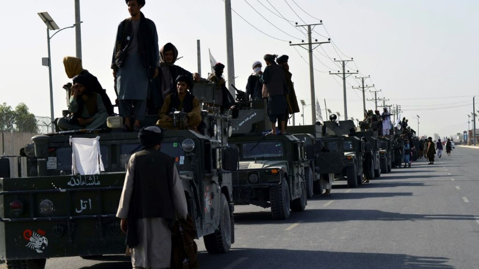 Des combattants talibans juchés sur des véhicules militaires américains se préparent à défiler le 1er septembre 2021 dans une rue de Kandahar, la grande ville du Sud de l'Afghanistan