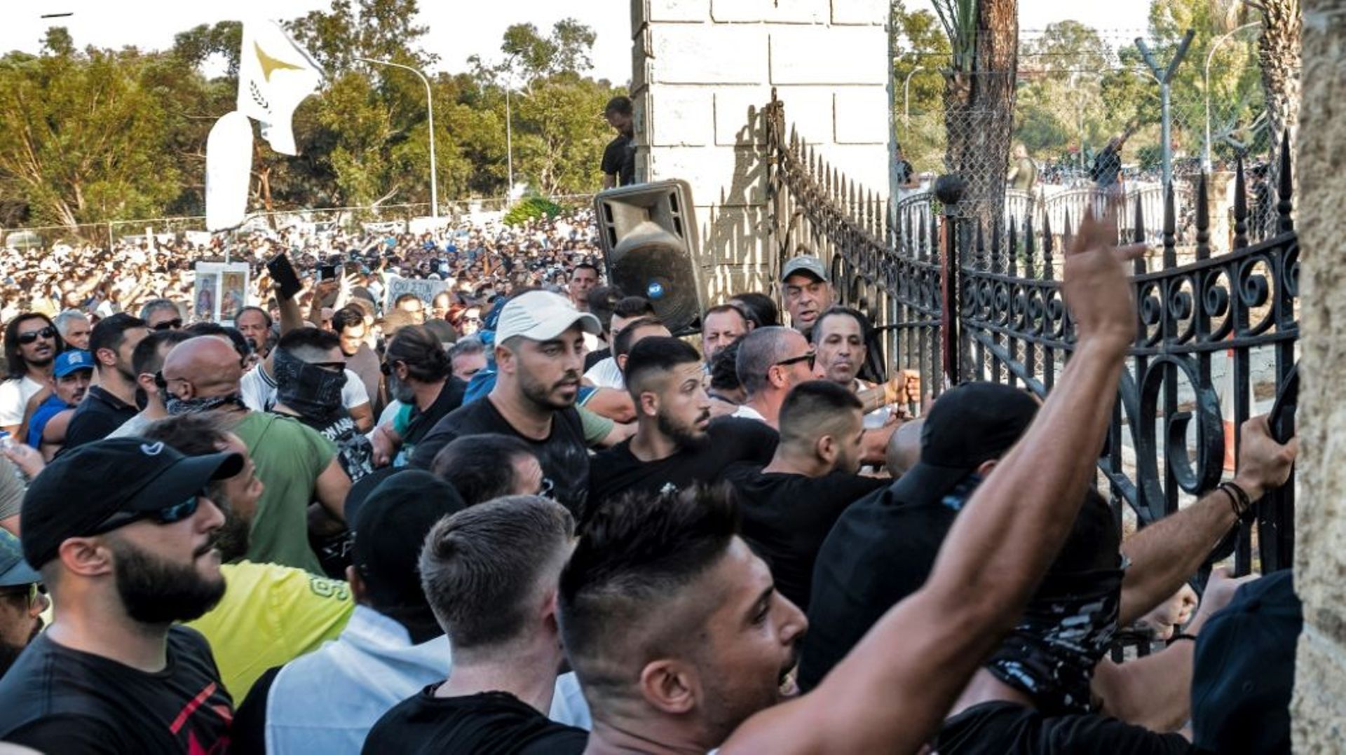 Des manifestants contre les restrictions liées à l’épidémie de Covid-19 sont rassemblés devant les grilles du palais présidentiel le 18 juillet 2021 à Nicosie