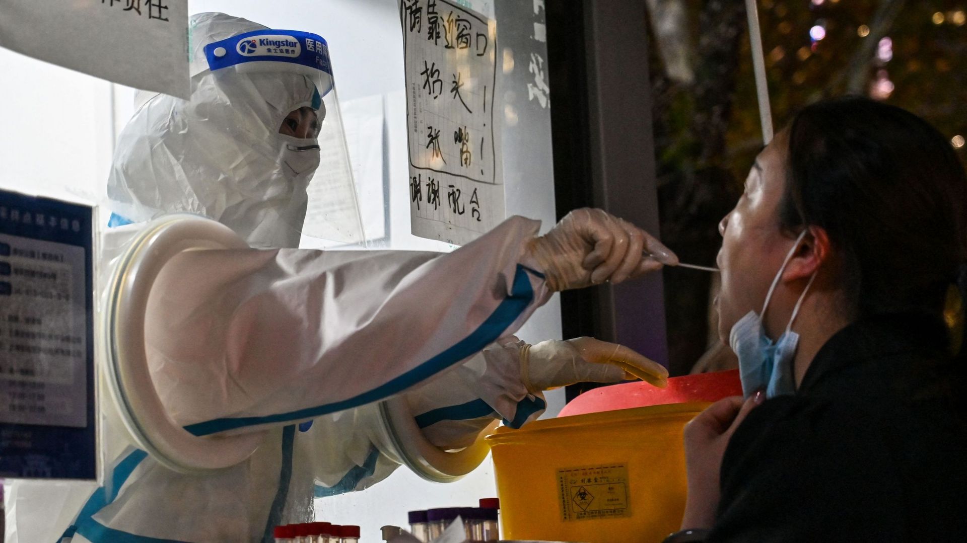 Un agent de santé prélève un échantillon sur une femme pour tester le coronavirus Covid-19 dans le quartier de Jing’an à Shanghai, le 28 novembre 2022. Des centaines de personnes sont descendues dans les rues des grandes villes chinoises dans un rare élan
