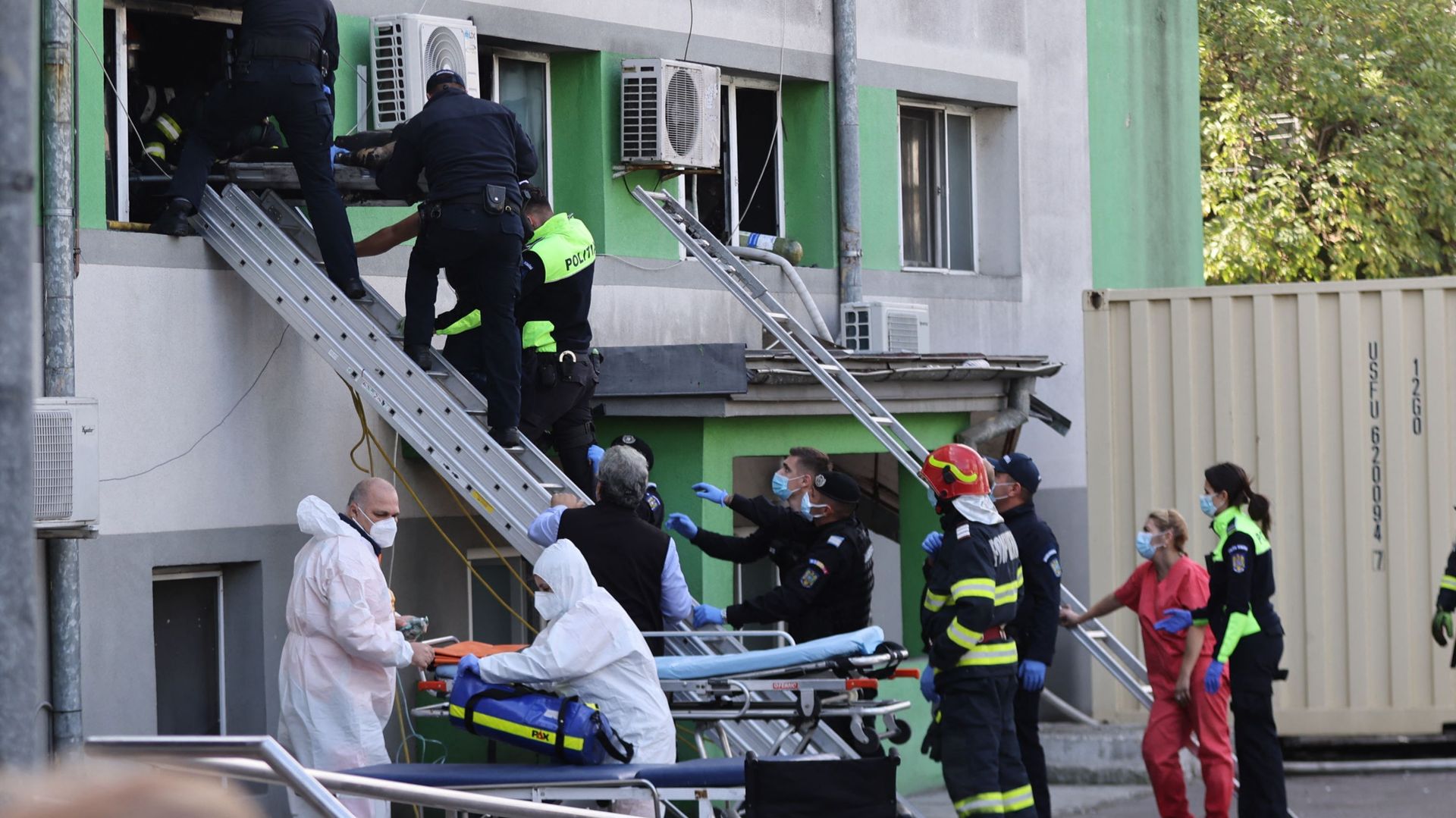 Des pompiers et des policiers évacuent une victime brûlée de l'hôpital des maladies infectieuses de Constanta, en Roumanie après un incendie dans l'unité de soins intensifs. Plusieurs patients du Covid-19 sont décédés. Cinq patients sont morts en janvier 