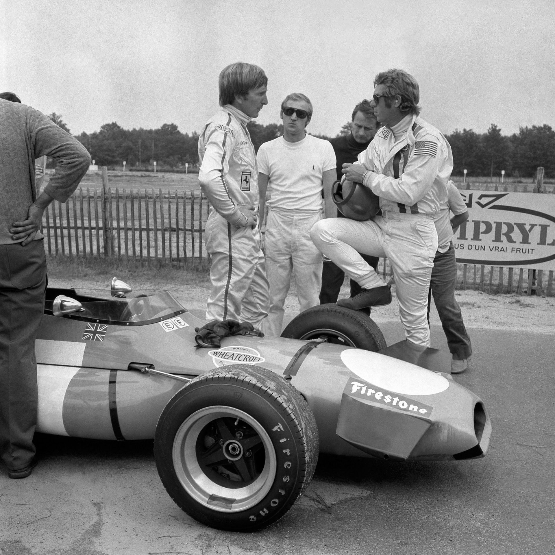 Le pilote britannique Derek Bell donne des conseils à l’acteur américain Steve McQueen au volant d’une Brabham F2, le 18 juillet 1970, au Mans lors du tournage du film 'Le Mans', réalisé par Lee H. Katzin et tourné pendant et après la 38e édition des 24 h