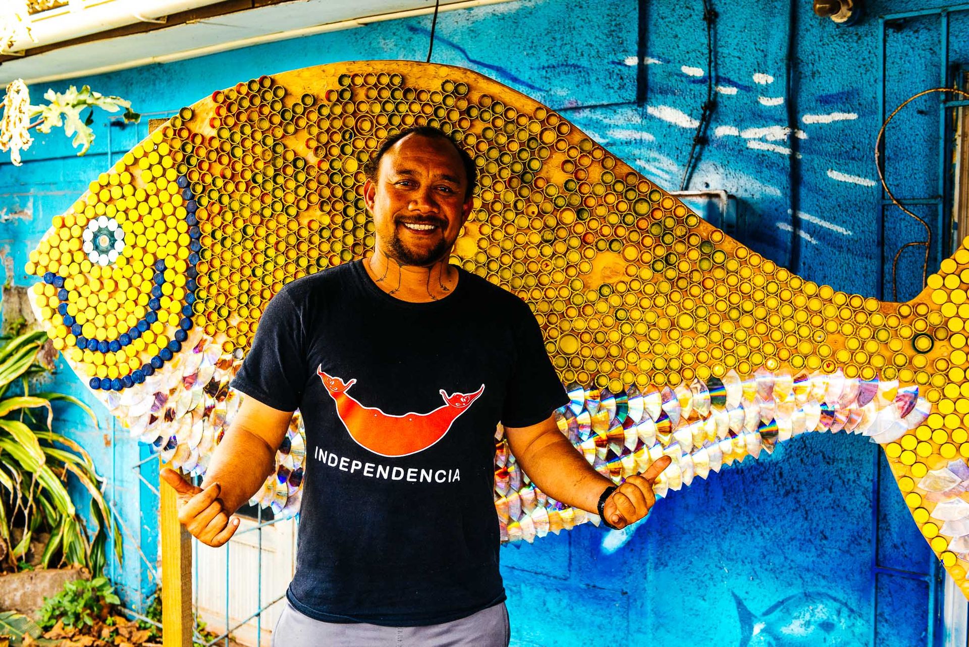 Ludovic Burns Tuki devant le logo de son ONG La Mesa del Mar