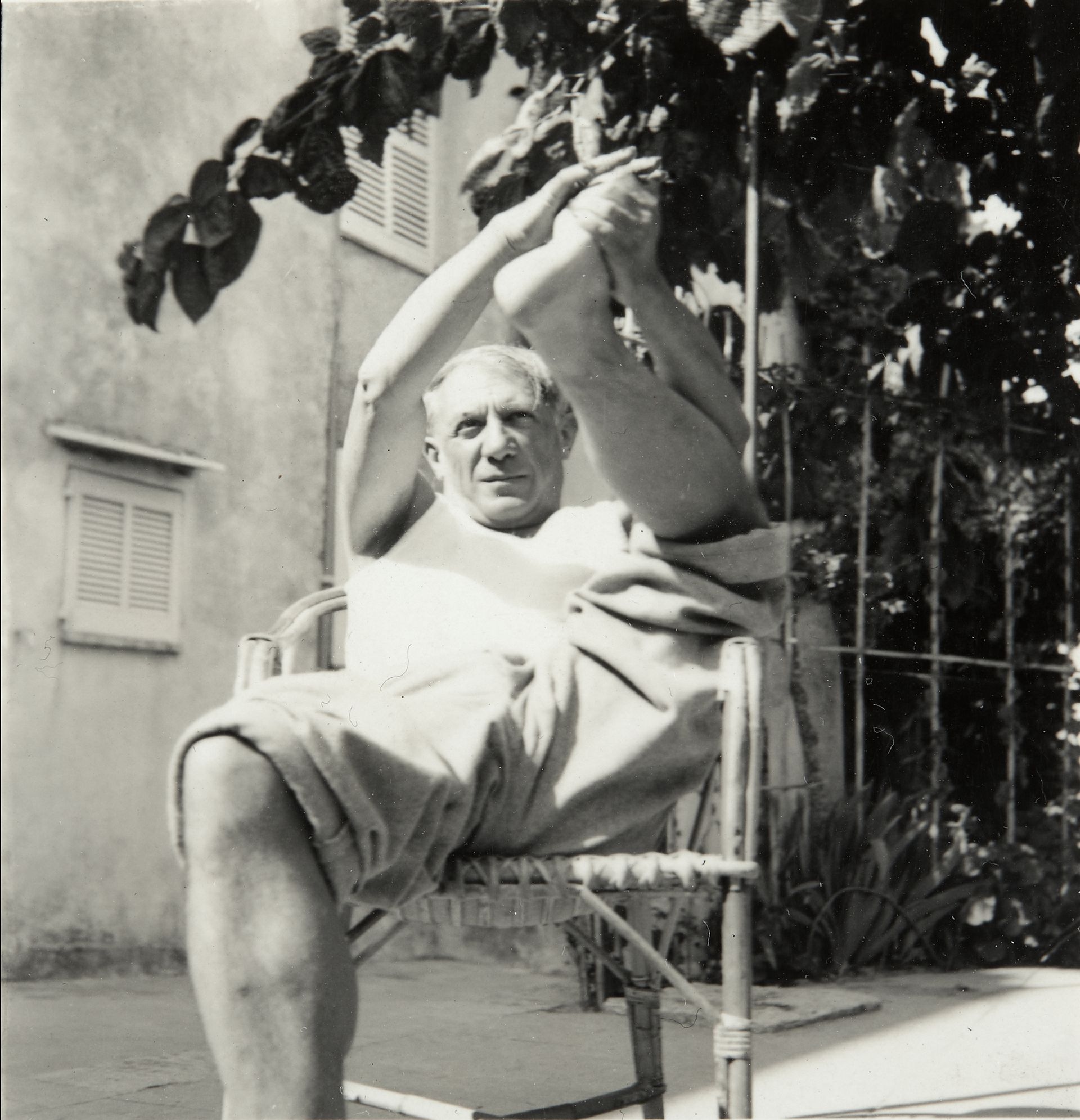 Pablo Picasso dans son fauteuil en rotin.
