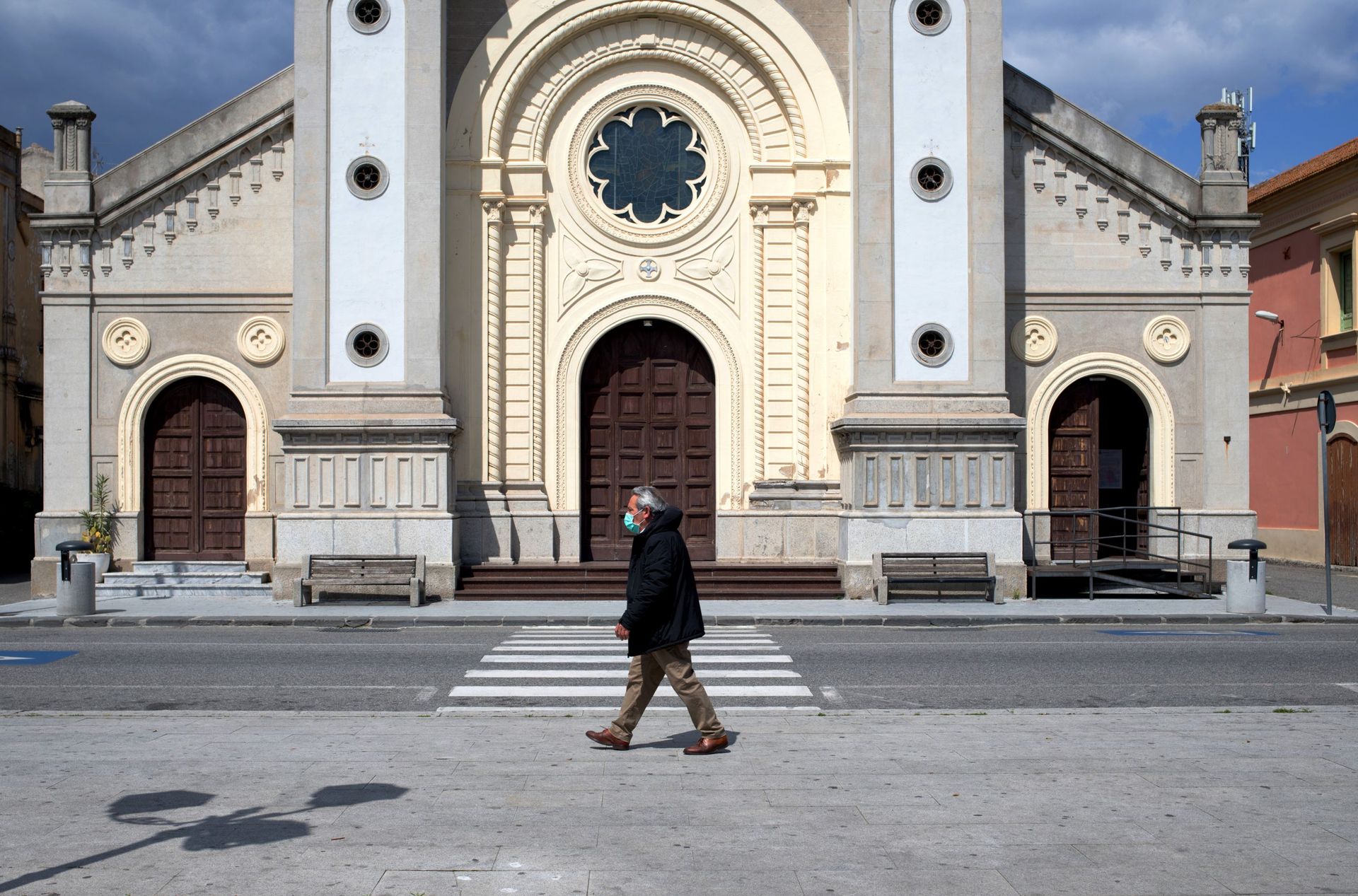 Passant avec un masque devant une église de Locri, en Calabre, le 08 avril 2020