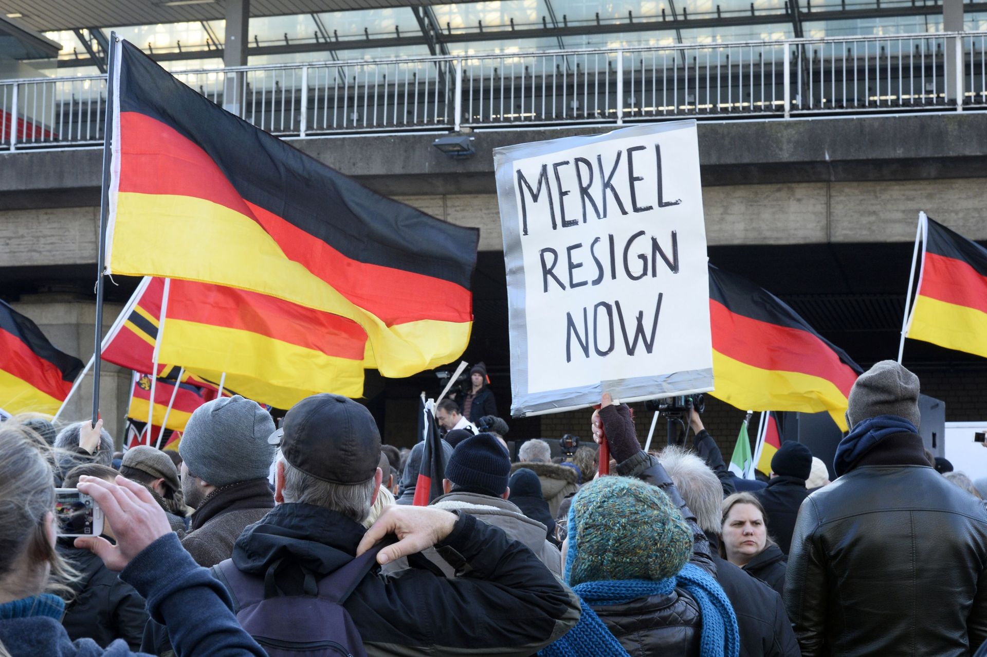 Des partisans d'extrême droite allemands manifestent à la gare de Cologne le 9 janvier 2016. En scandant "Merkel out" et en agitant des drapeaux allemands, les partisans du mouvement xénophobe PEGIDA exprimaient leur colère contre les migrants.