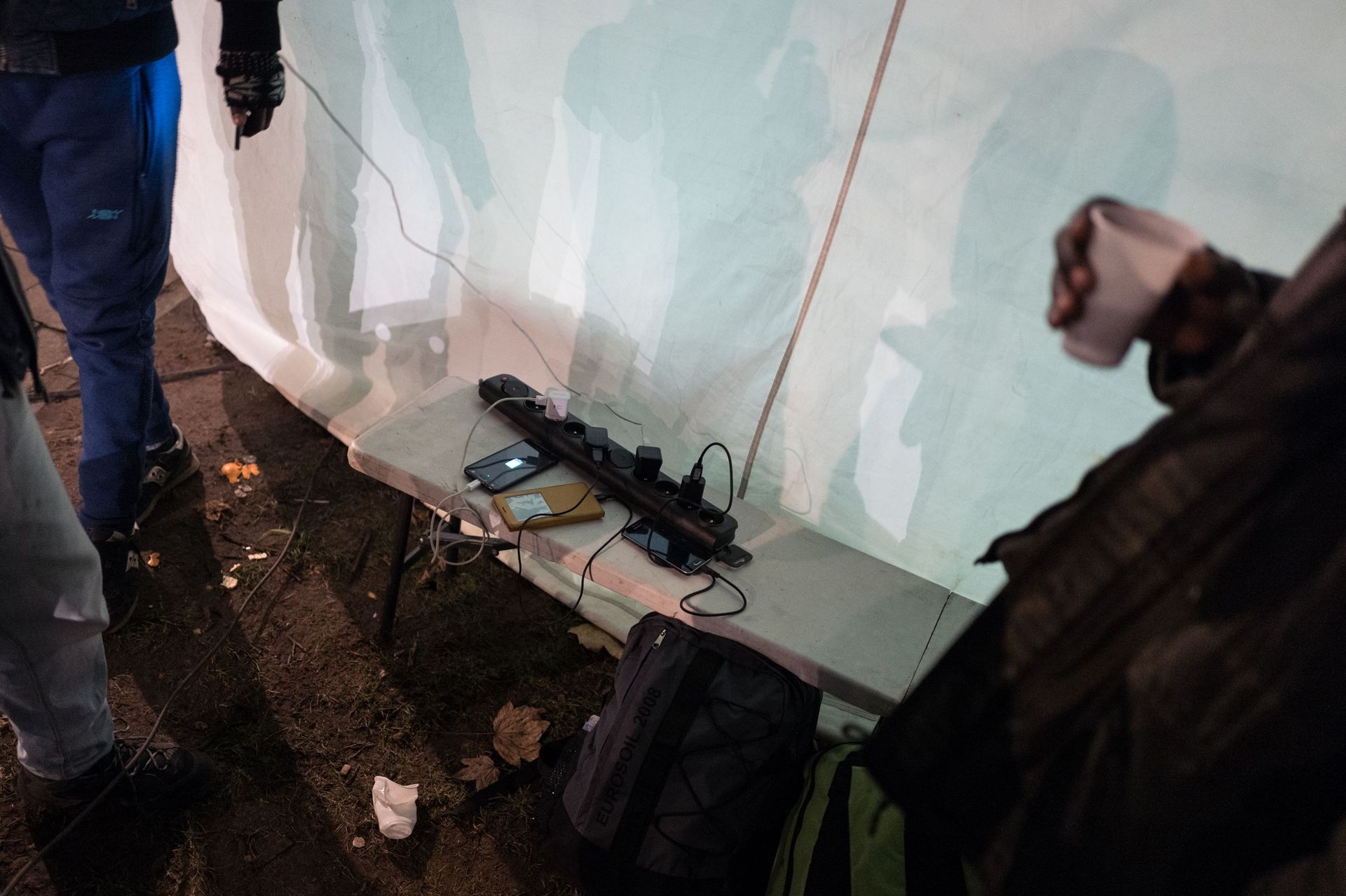 En attendant un hébergement fourni par la plate-forme citoyenne, des migrants rechargent leurs téléphones grâce aux prises fournies par la Croix-Rouge
