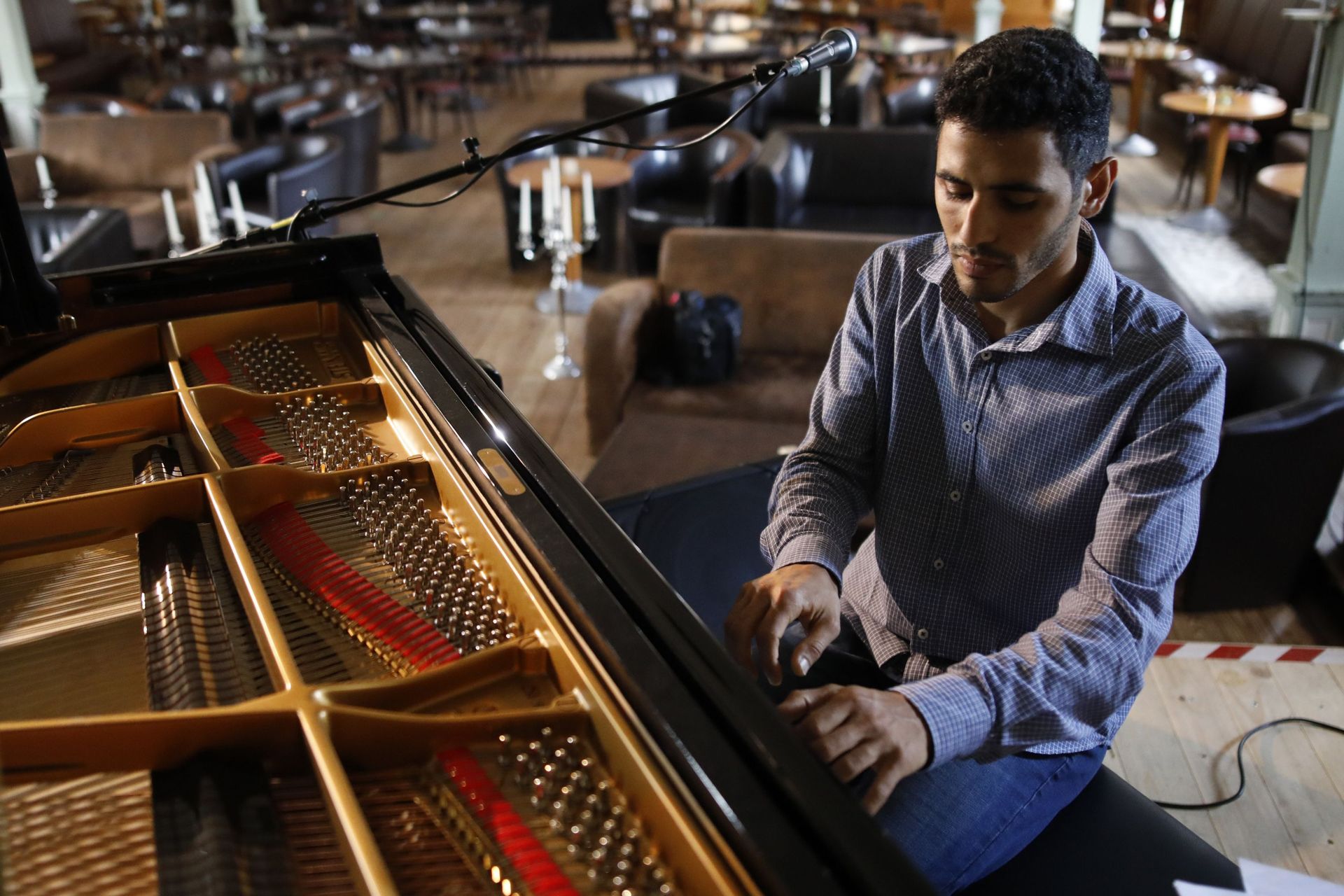 
Aeham Ahmad, pianiste syrien et réfugié du camp de réfugiés de Yarmouk à Damas, répète avant un concert le 30 août 2020 dans le centre culturel `` One World '' à Reinstorf près de Lunebourg, dans le nord de l'Allemagne