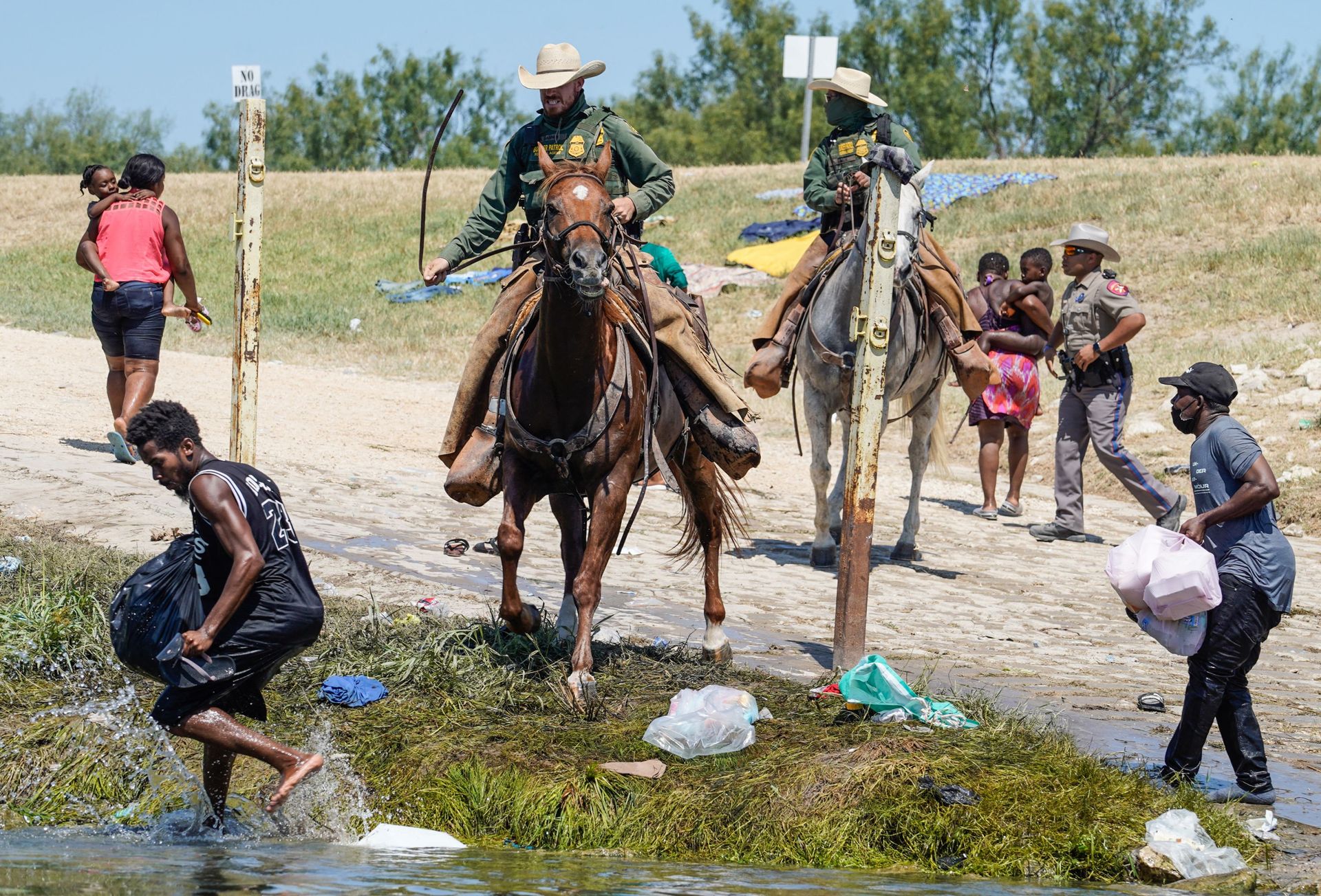Des agents de la patrouille frontalière des États-Unis à cheval tentent d’empêcher des migrants haïtiens d’entrer dans un campement sur les rives du Rio Grande près du pont international Acuna Del Rio à Del Rio, au Texas, le 19 septembre 2021.