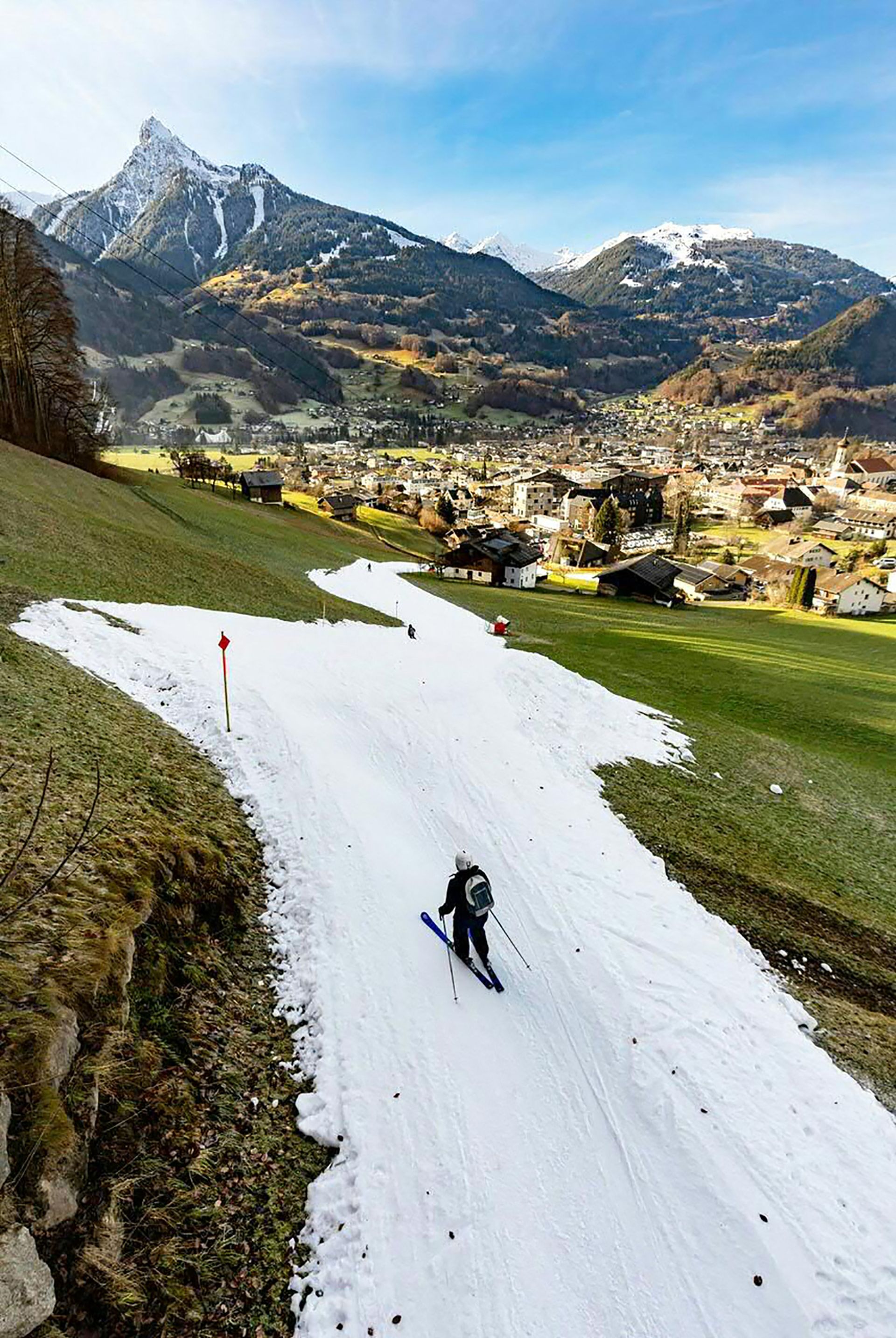 Un touriste skieur glisse sur une piste de ski au milieu d’espaces verts à Schruns, en Autriche, le 28 décembre 2022. Comme d’autres régions d’Europe, l’Autriche a connu des températures relativement élevées au cours de la semaine dernière.