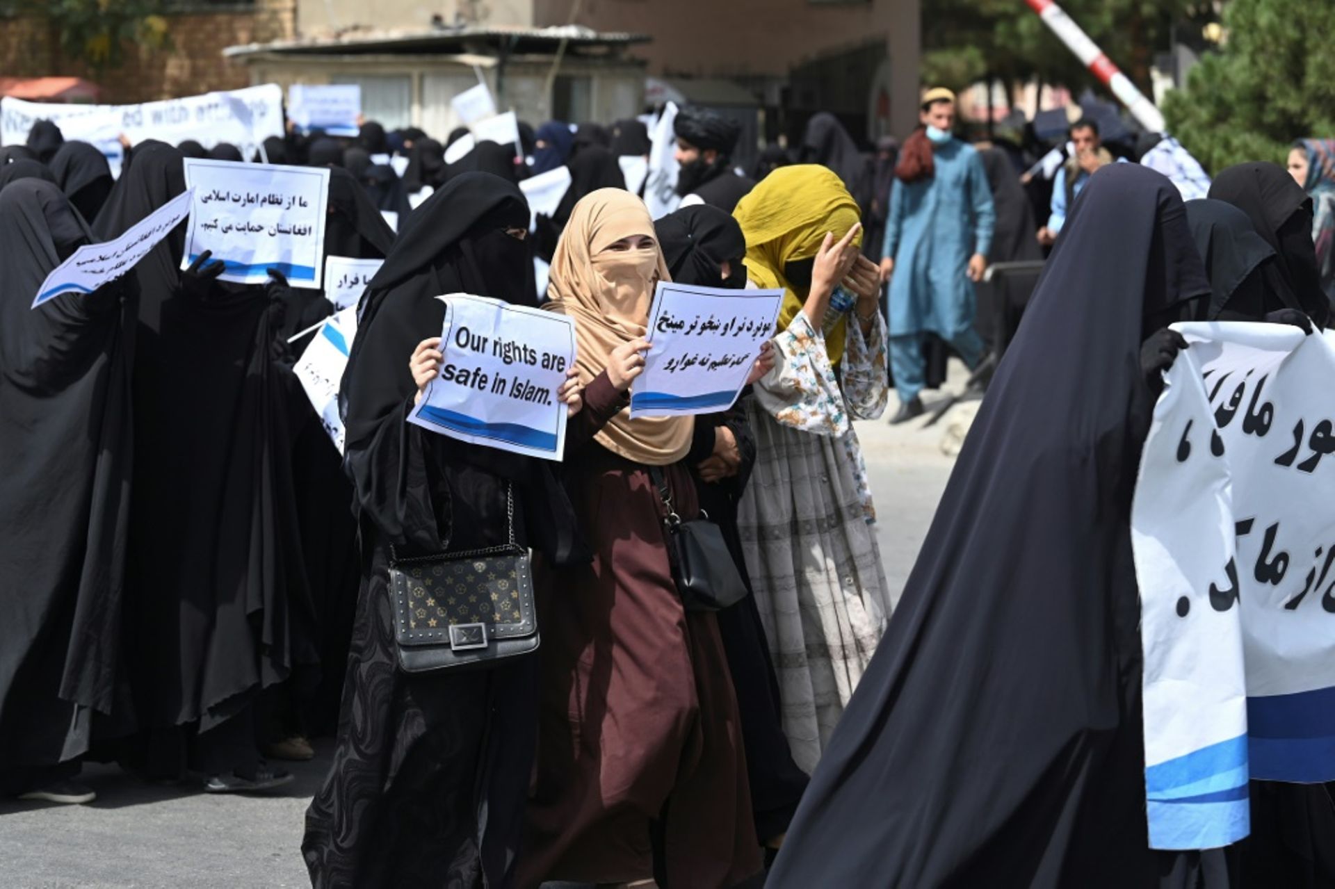 Des Afghanes en niqabs noirs défilent avec des pancartes pro-talibans devant l’université Shaheed Rabbani, le 11 septembre 2021 à Kaboul