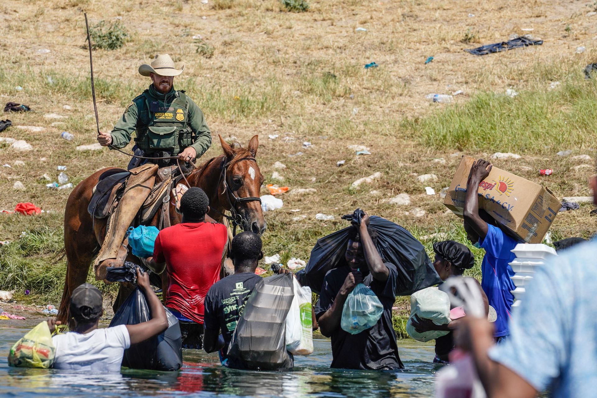 Un agent de la patrouille frontalière des États-Unis à cheval utilise les rênes alors qu’il tente d’empêcher des migrants haïtiens d’entrer dans un campement sur les rives du Rio Grande près du pont international Acuna Del Rio à Del Rio, au Texas, le 19 s
