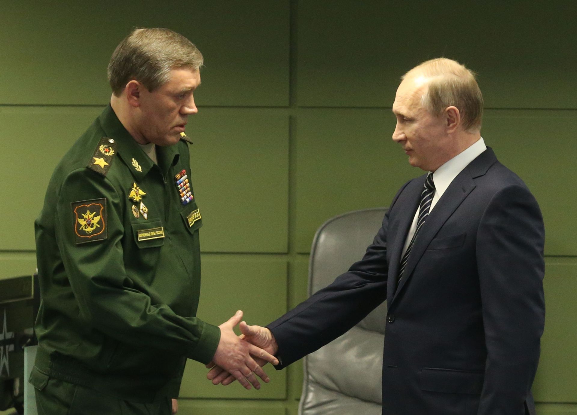 Le président russe Vladimir Poutine (R) salue le chef d’état-major général des forces armées Valery Gerasimov (L) lors de la visite du Centre de défense nationale à Moscou, en Russie, le 11 mars 2016.