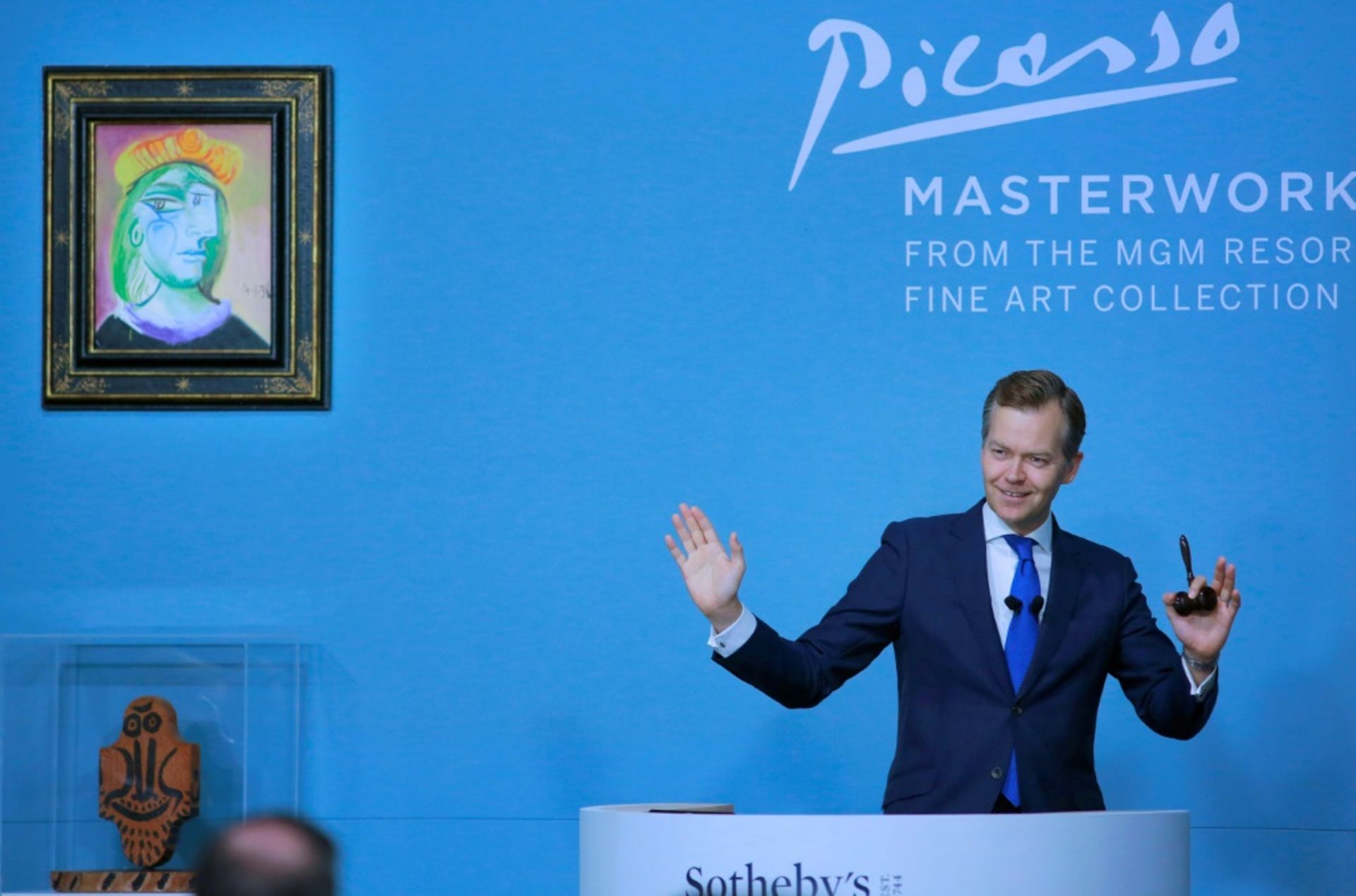 Oliver Barker, commissaire-priseur de Sotheby's, lors d'une vente aux enchères de 11 oeuvres de Picasso provenant de la collection de MGM Resorts dont la "Femme au béret rouge-orange" (en haut à g), le 23 octobre 2021 à Las Vegas 
