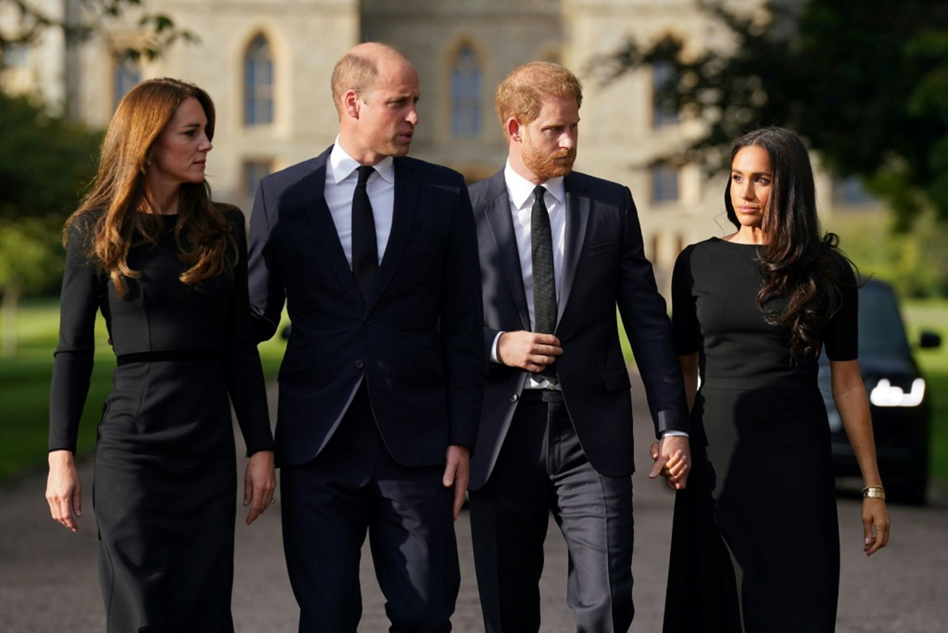Catherine, princesse de Galles, William, prince de Galles, le prince Harry, duc de Sussex, et son épouse Meghan, duchesse de Sussex (de gauche à droite) marchent à la rencontre des badauds au château de Windsor (Royaume-Uni), le 10 septembre 2022
