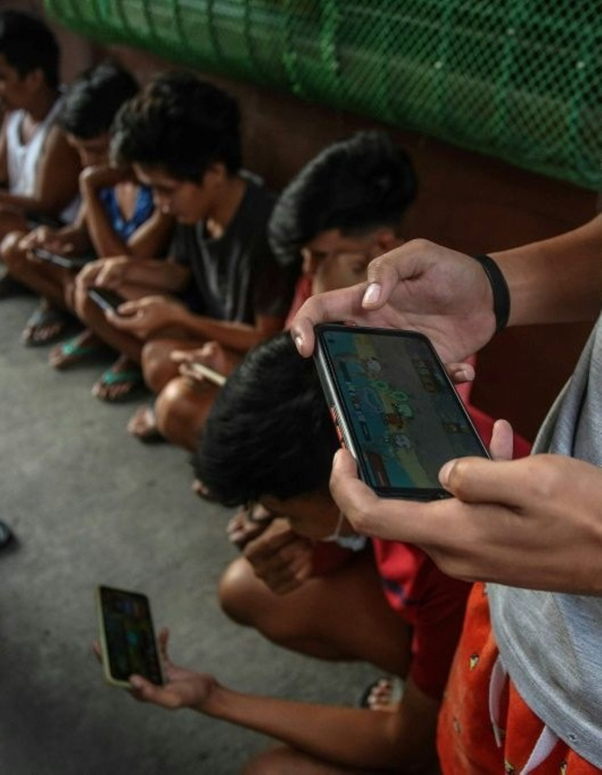 Des gamers jouent sur leurs smartphones au jeu vidéo NFT Axie Infinity, le 15 décembre 2021 à Malabon, dans la banlieue de Manille, aux Philippines