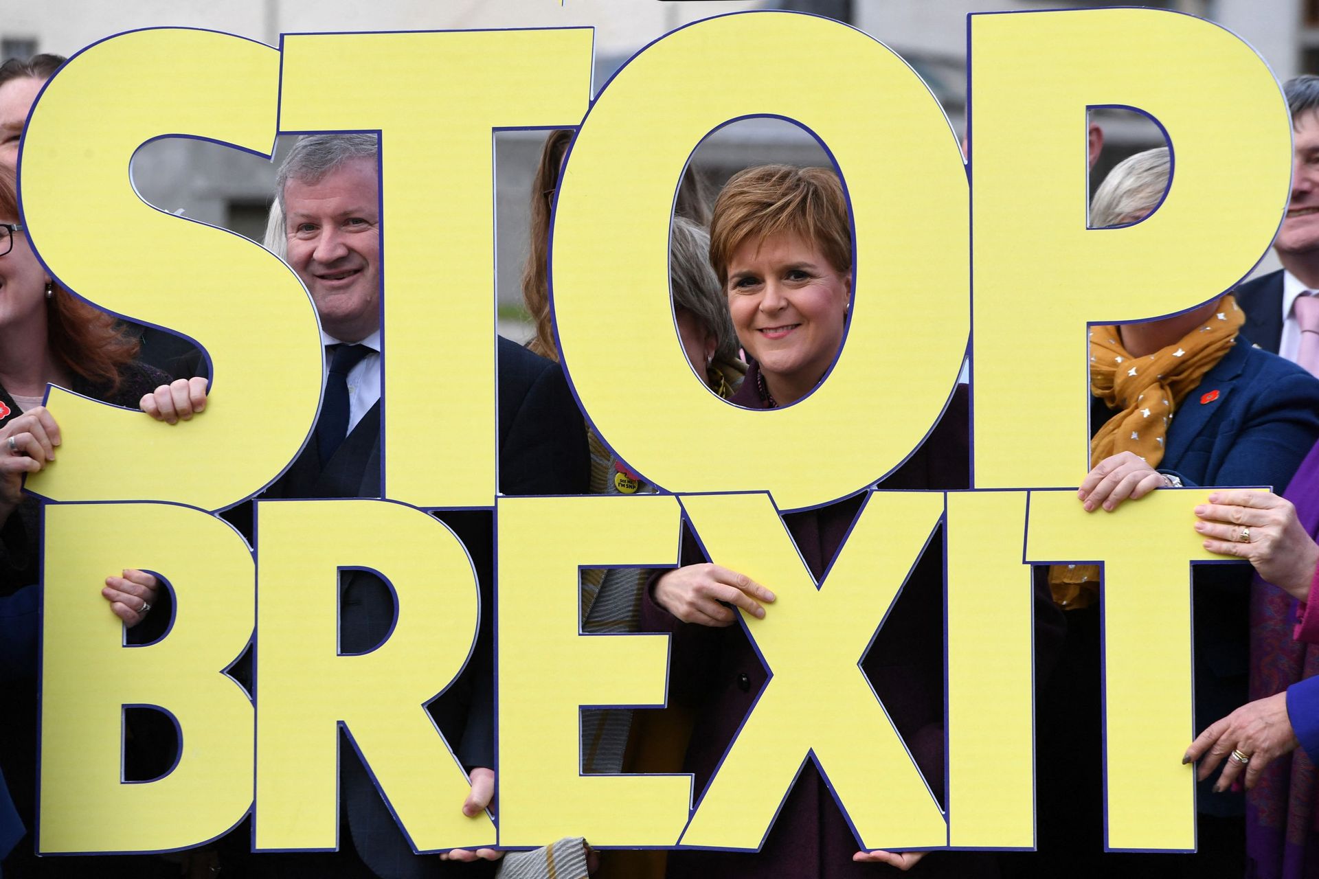 Le chef du Parti nationaliste écossais (SNP) Nicola Sturgeon pose avec des membres du parti et un "Stop Brexit ".