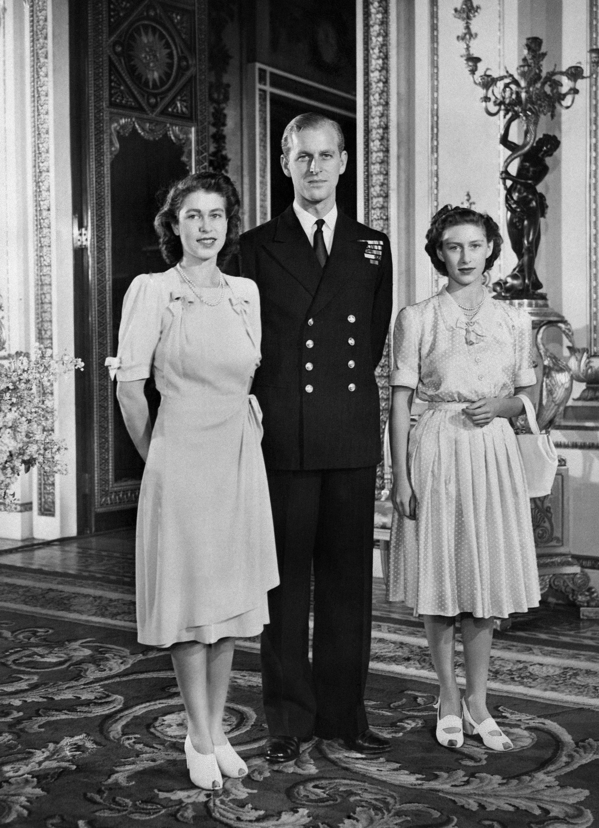 Princess Elizabeth (future Queen Elizabeth II), Philip Mountbatten (also the Duke of Edinburgh) and Princess Margaret pose in the Buckingham Palace on July 09, 1947 in London, the day their engagement was officially announced.