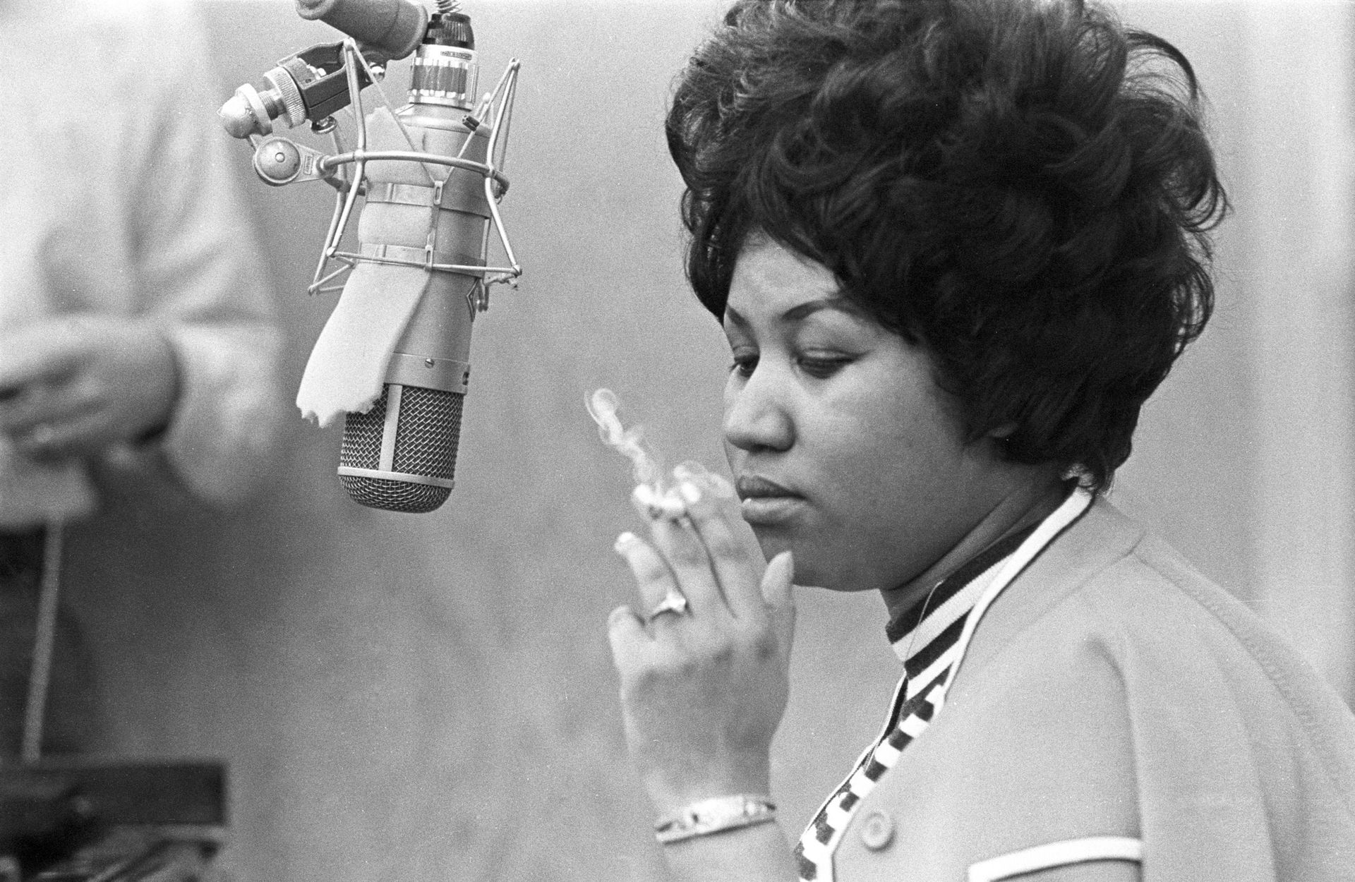 La chanteuse Aretha Franklin fume une cigarette alors qu'elle travaille en studio près d'un micro aux Muscle Shoals Studios le 9 janvier 1969 à Muscle Shoals, Alabama. 