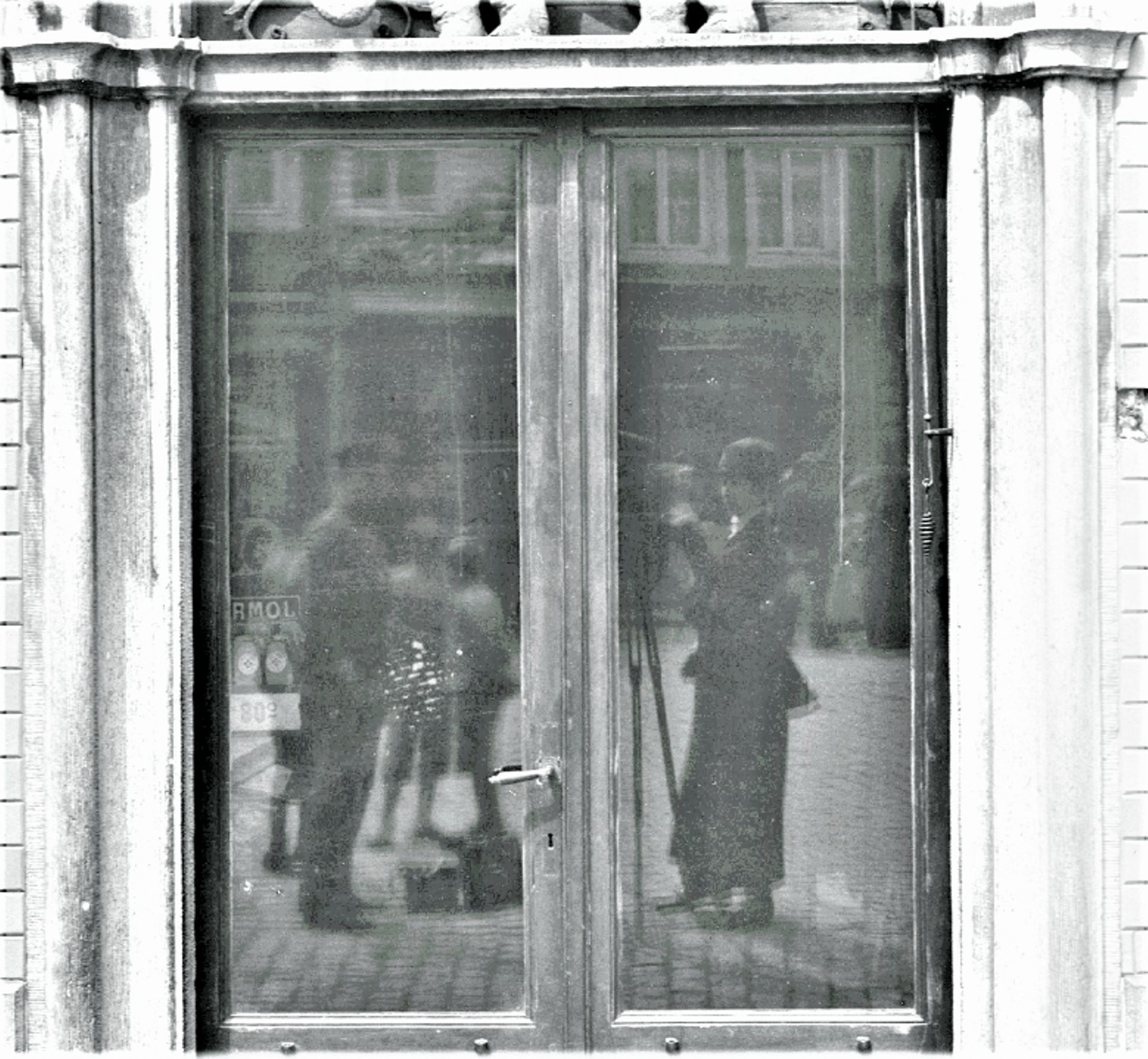Détail du reflet de Paula Deetjen dans la vitre de la porte de la maison "De Olifant", à Hal.