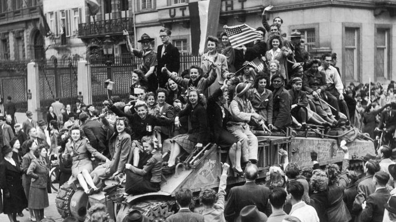 Des jeunes filles belges grimpent sur un char britannique lors de la libération de Bruxelles le 5 septembre 1944.