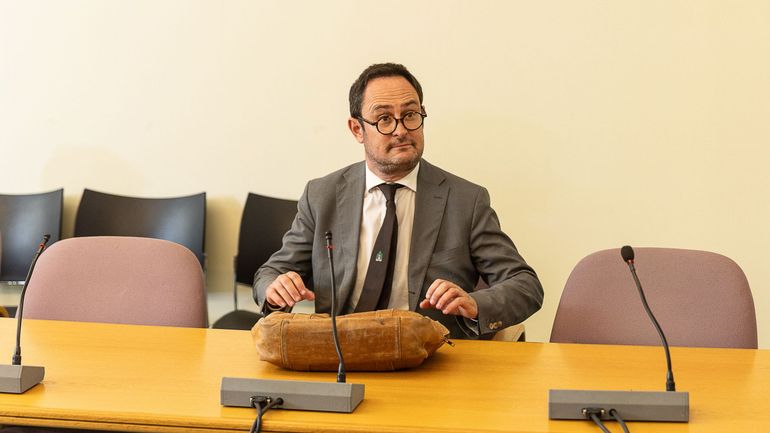 L'ancien ministre de la Justice se faufile parmi les journalistes lors d'un briefing sur la taxe sur les plus-values, il est prié de quitter la salle